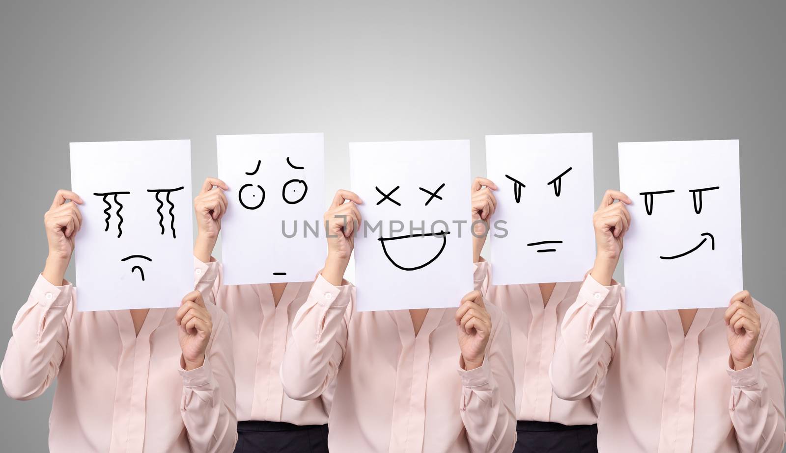 five businesswoman holding a card with drawing facial expressions different emotion feelings face on white paper