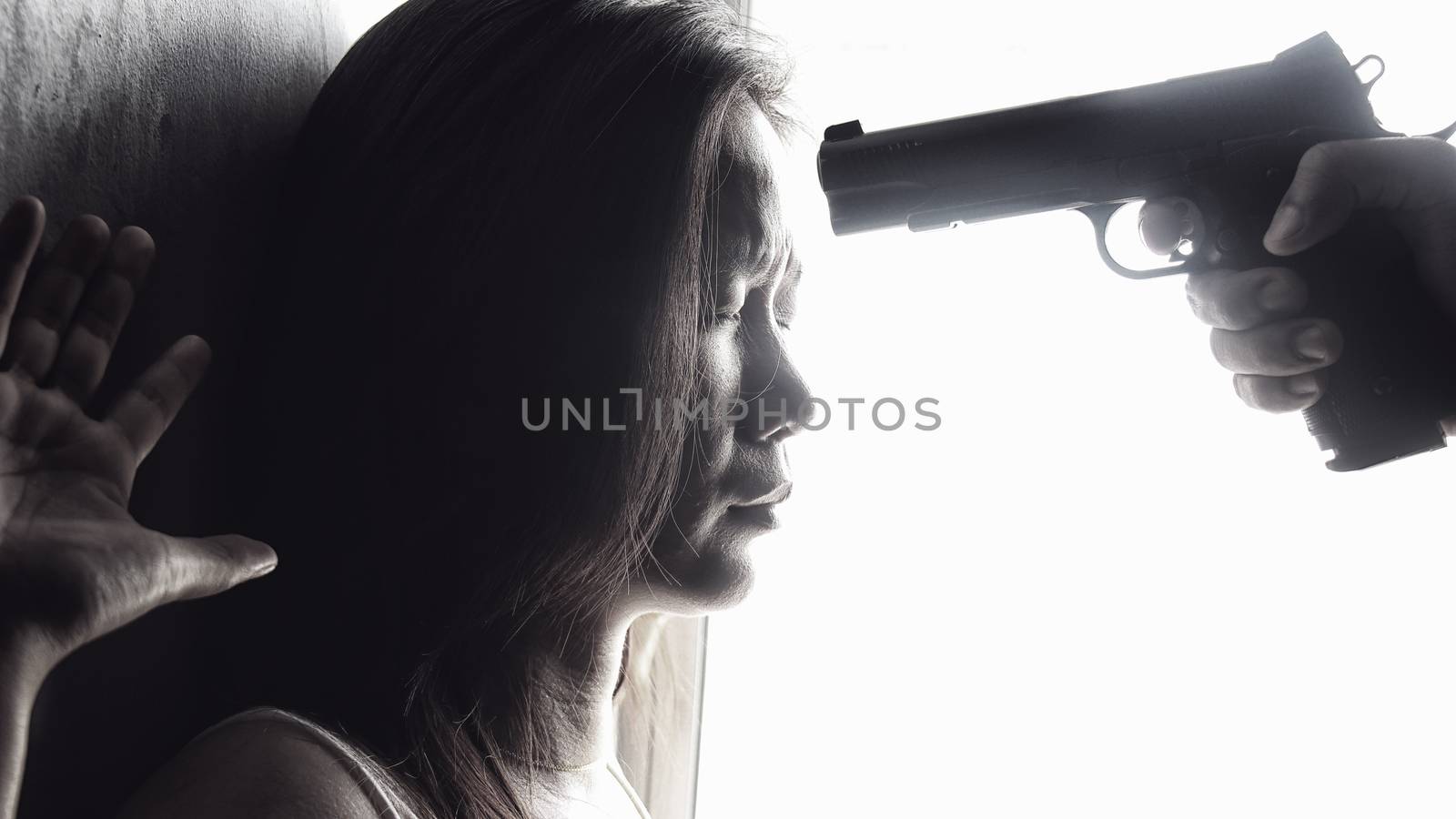 man use handgun aim on women's heads for intimidate. stop domestic violence against women campaign. reform gun control concept by asiandelight