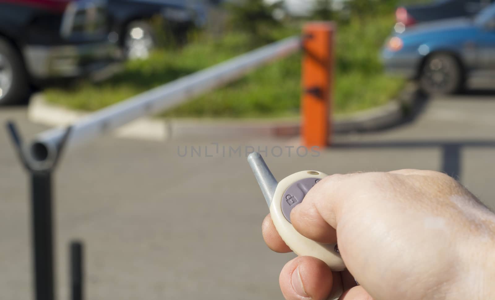 a person with a remote control opens an automatic barrier in the Parking lot by pressing the button