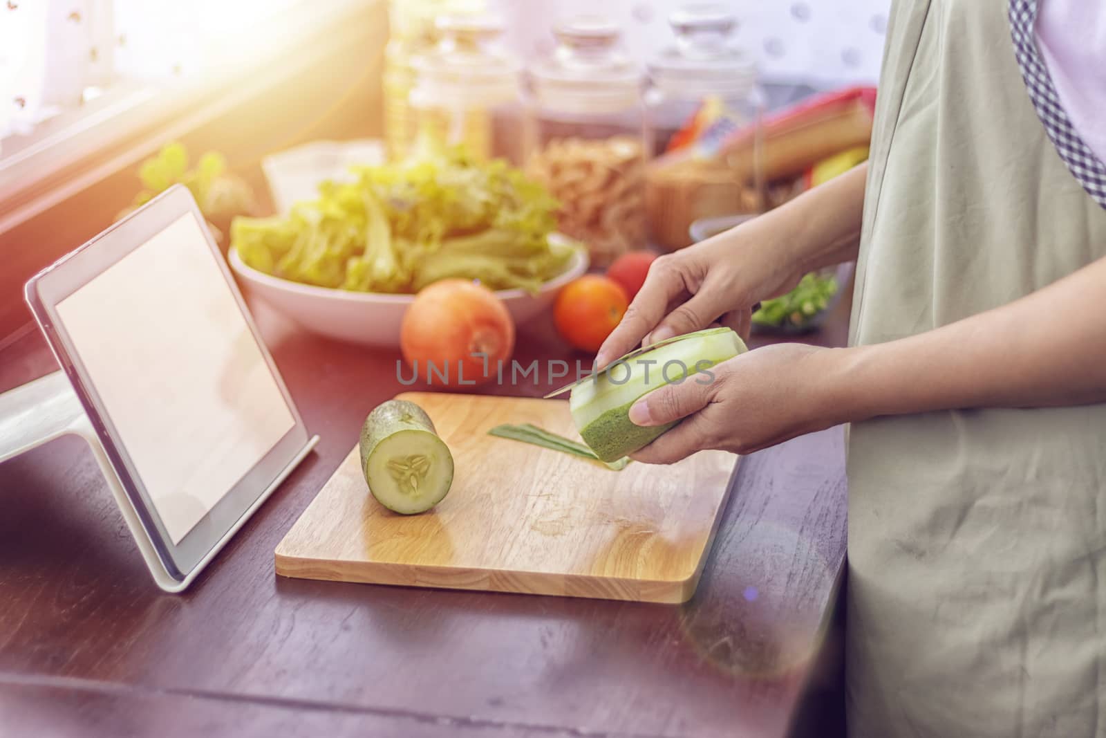 female hand slicing green vegetable, prepare ingredients for cooking follow cooking online video clip on website via tablet. cooking content on internet technology for modern lifestyle concept by asiandelight