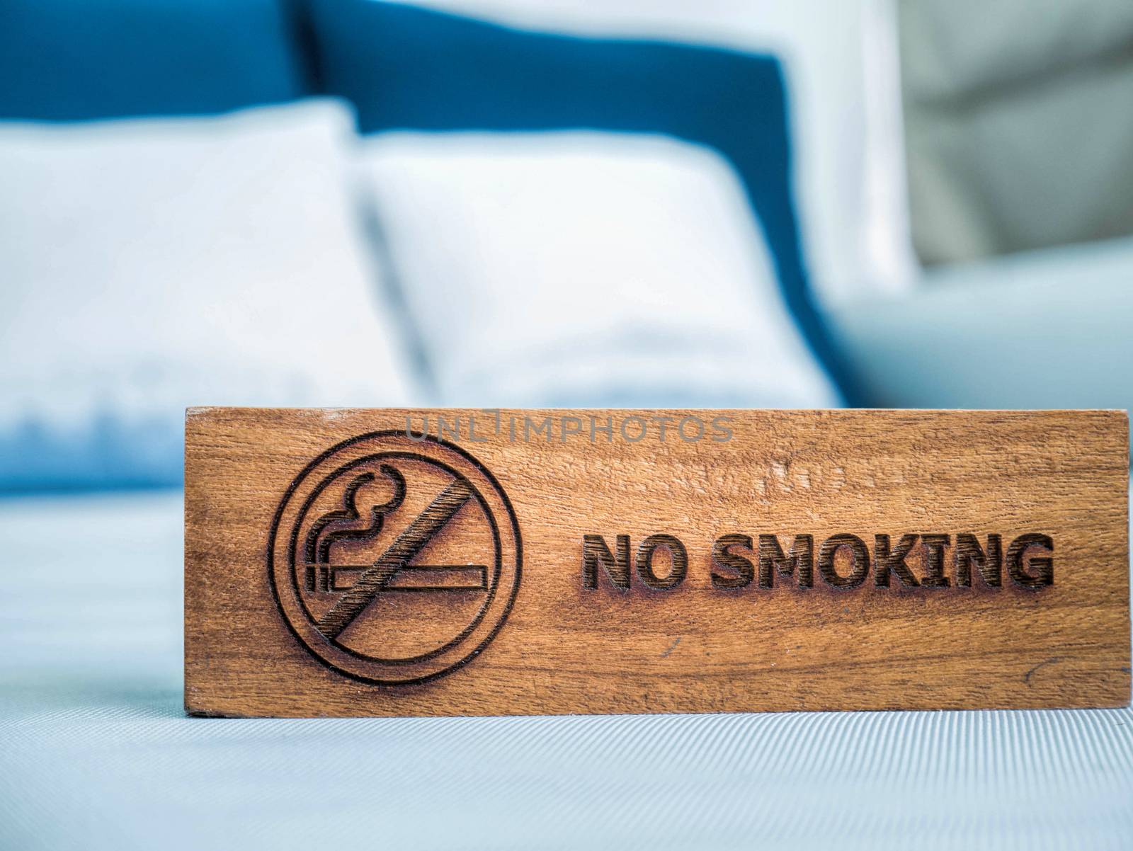 no smoking sign on the white sheet bed in hotel room