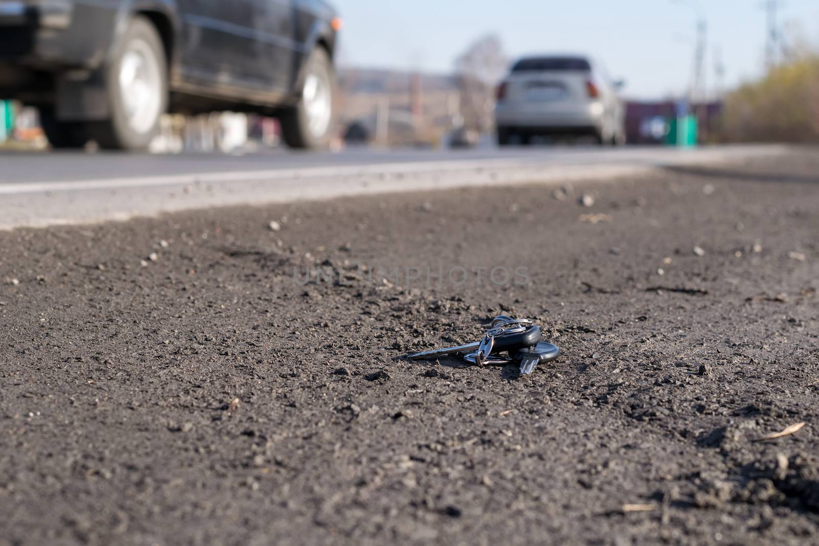 Lost bunch of keys lying on the side of the road near the asphalt pavement of the roadway