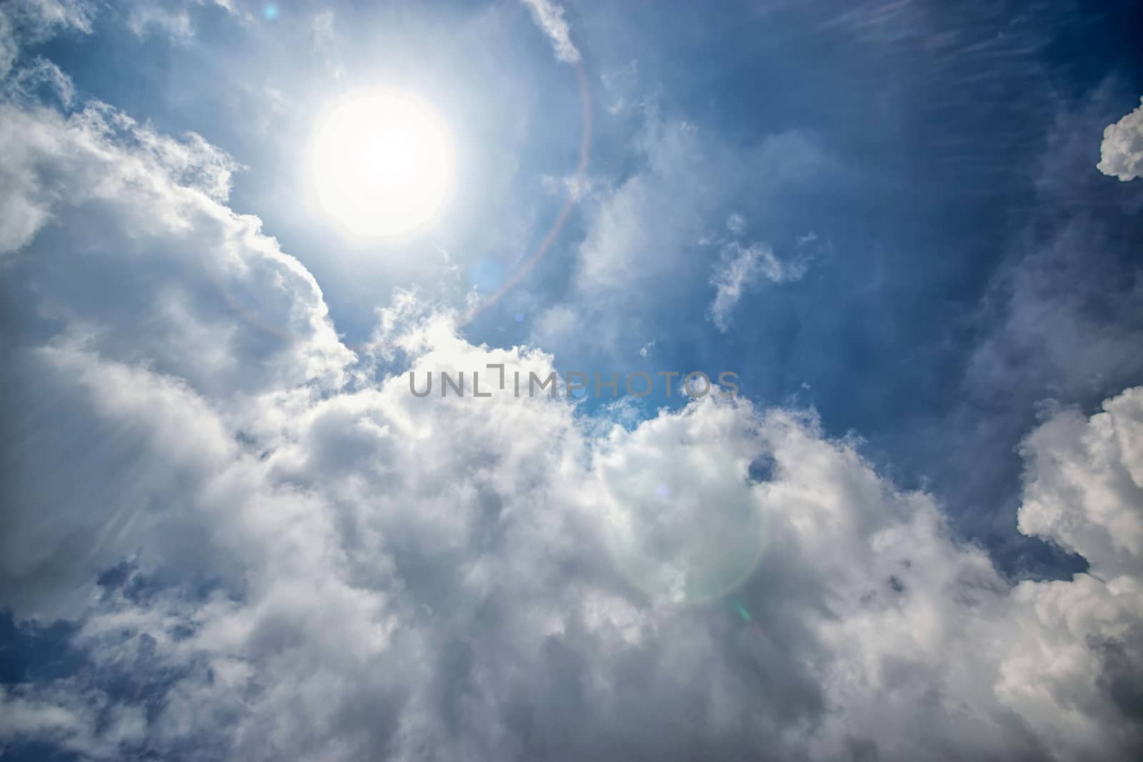 sunny background, blue sky with white clouds and sunlight flare