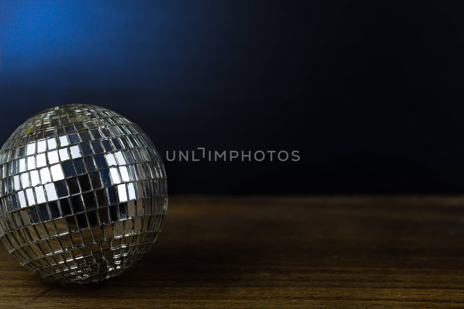 Disco ball on dark wooden floor background detail object art