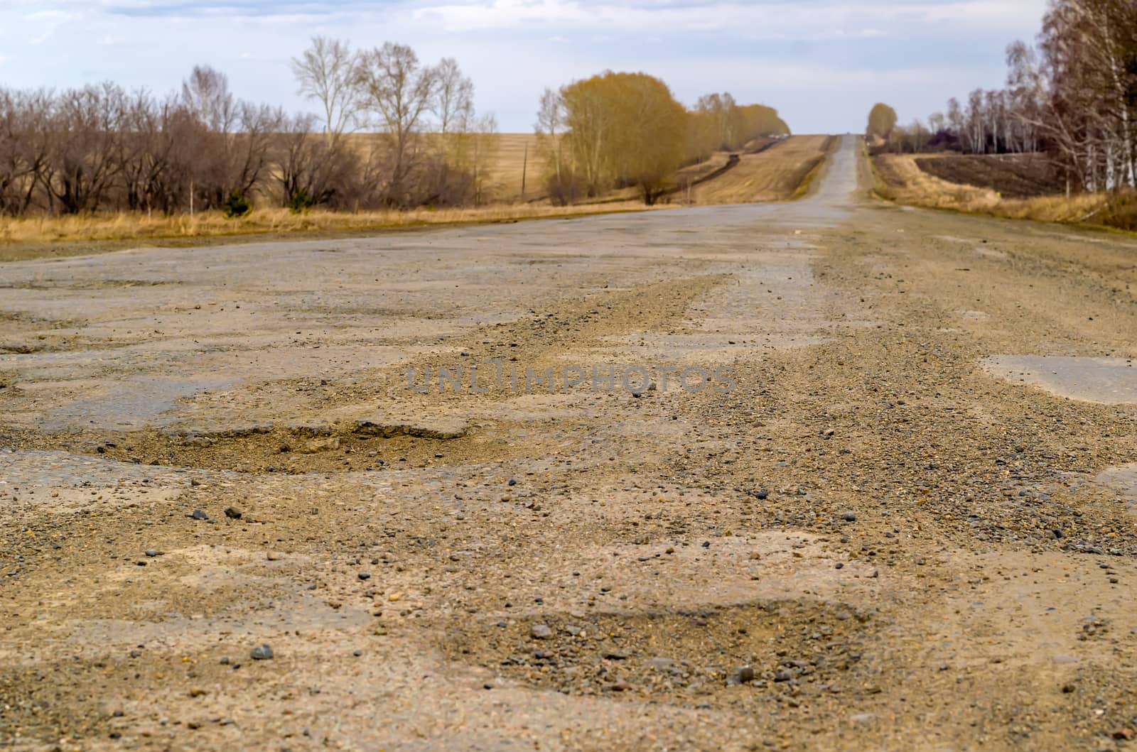 Pits on a country road. Damaged asphalt on the track