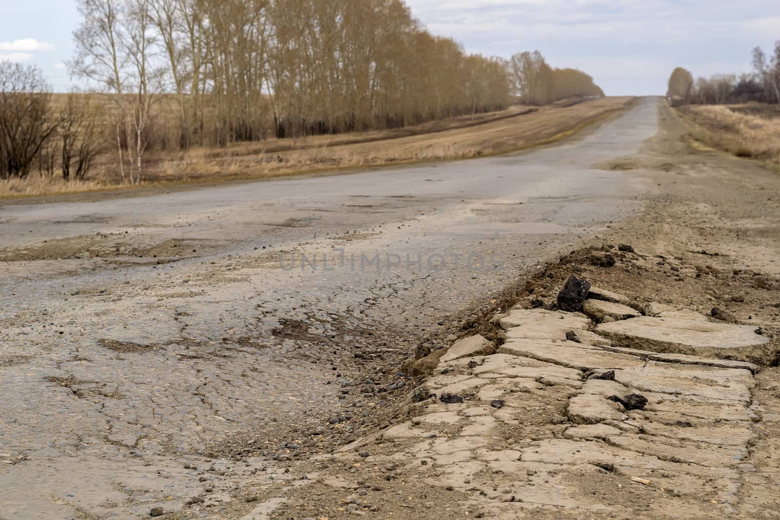 Pits on a country road. Damaged asphalt on the track