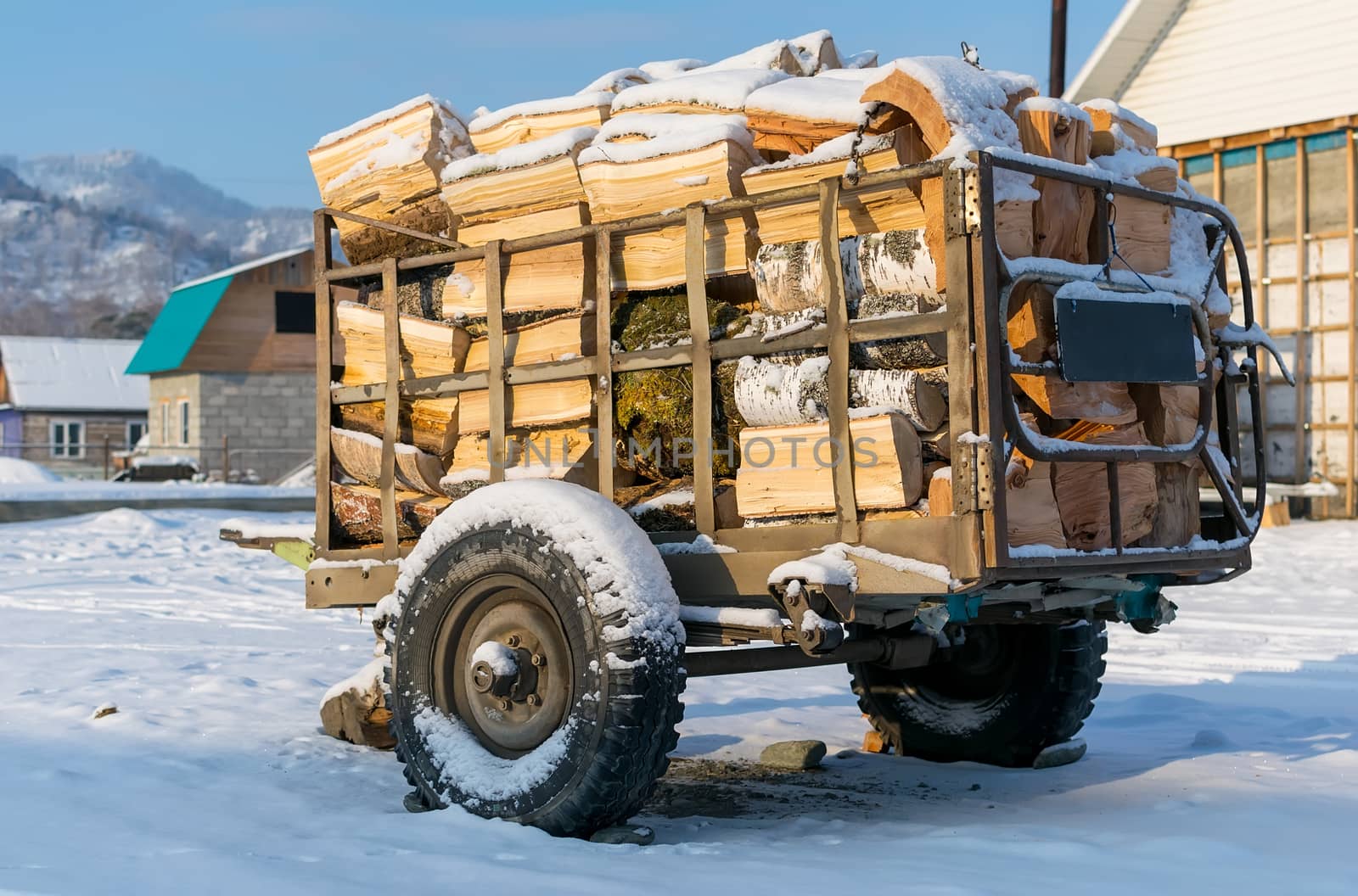 Cart, trailer, wagon for transportation of firewood is for sale in the countryside in the snow in winter