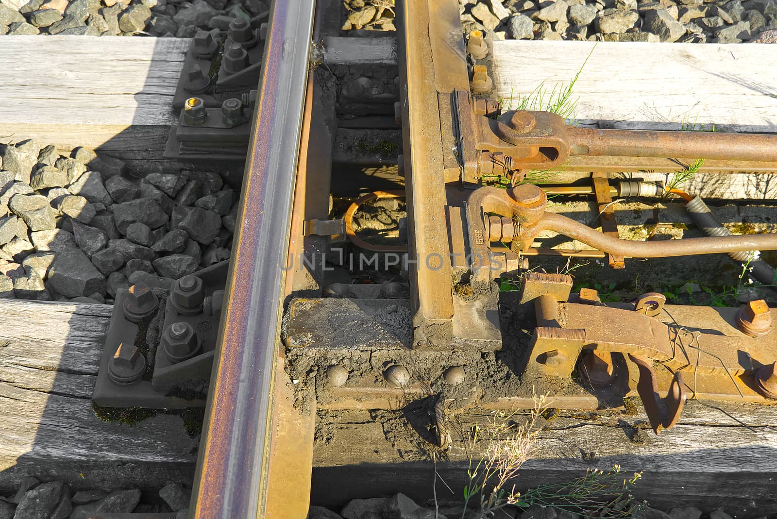 Railroad closeup. Railway tracks, Iron rusty train railway detail over dark stones. by PhotoTime