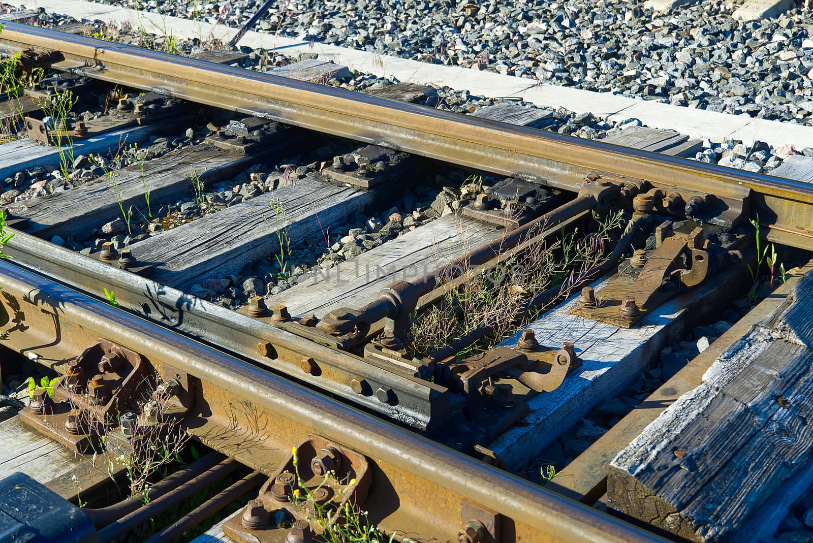Railroad closeup. Railway tracks, Iron rusty train railway detail over dark stones. by PhotoTime