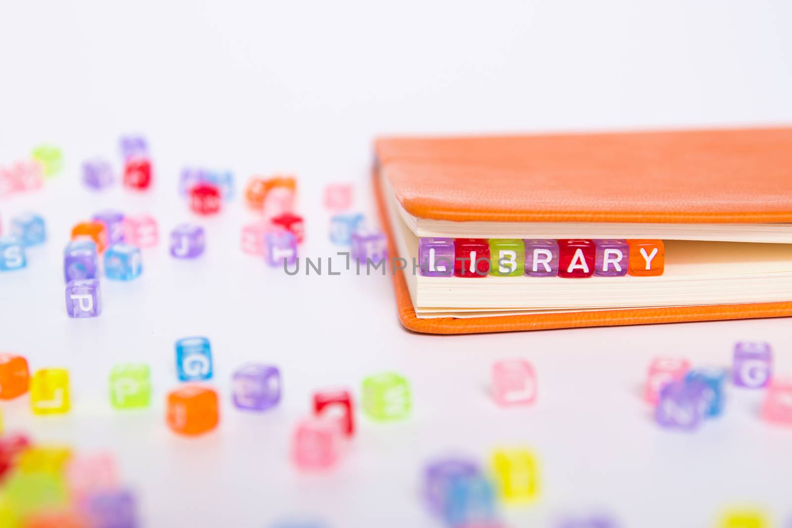 LIBRARY word on colorful bead block as bookmark in book. knowledge from book resource in library concept