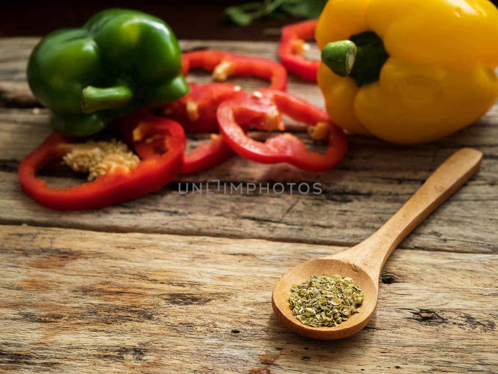 close up wooden spoon with utensils herbs , colorful bell pepper at background. healthy food menu and cooking concept