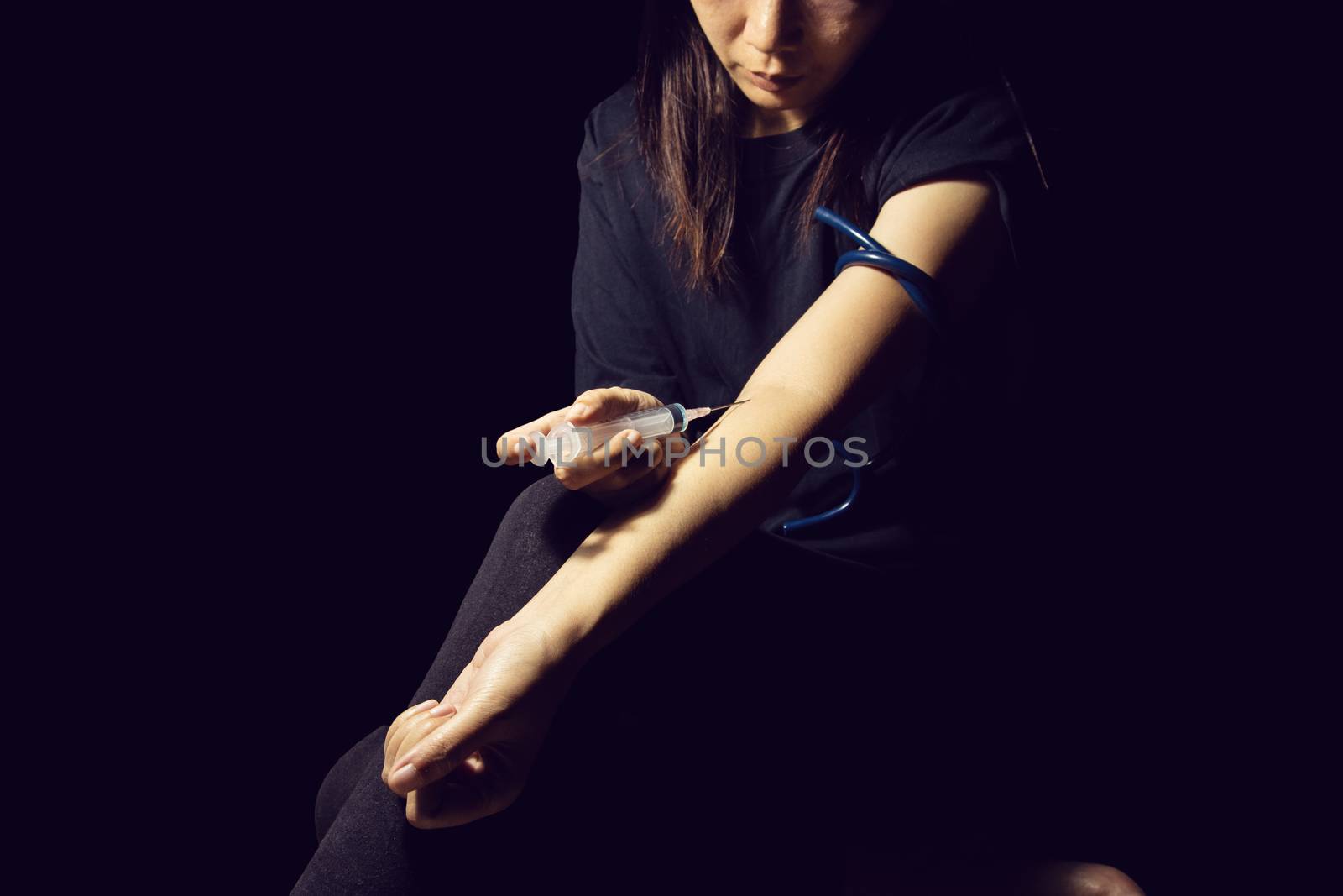 drug addict woman use syringe injecting drugs in her arm. drugs addict concept