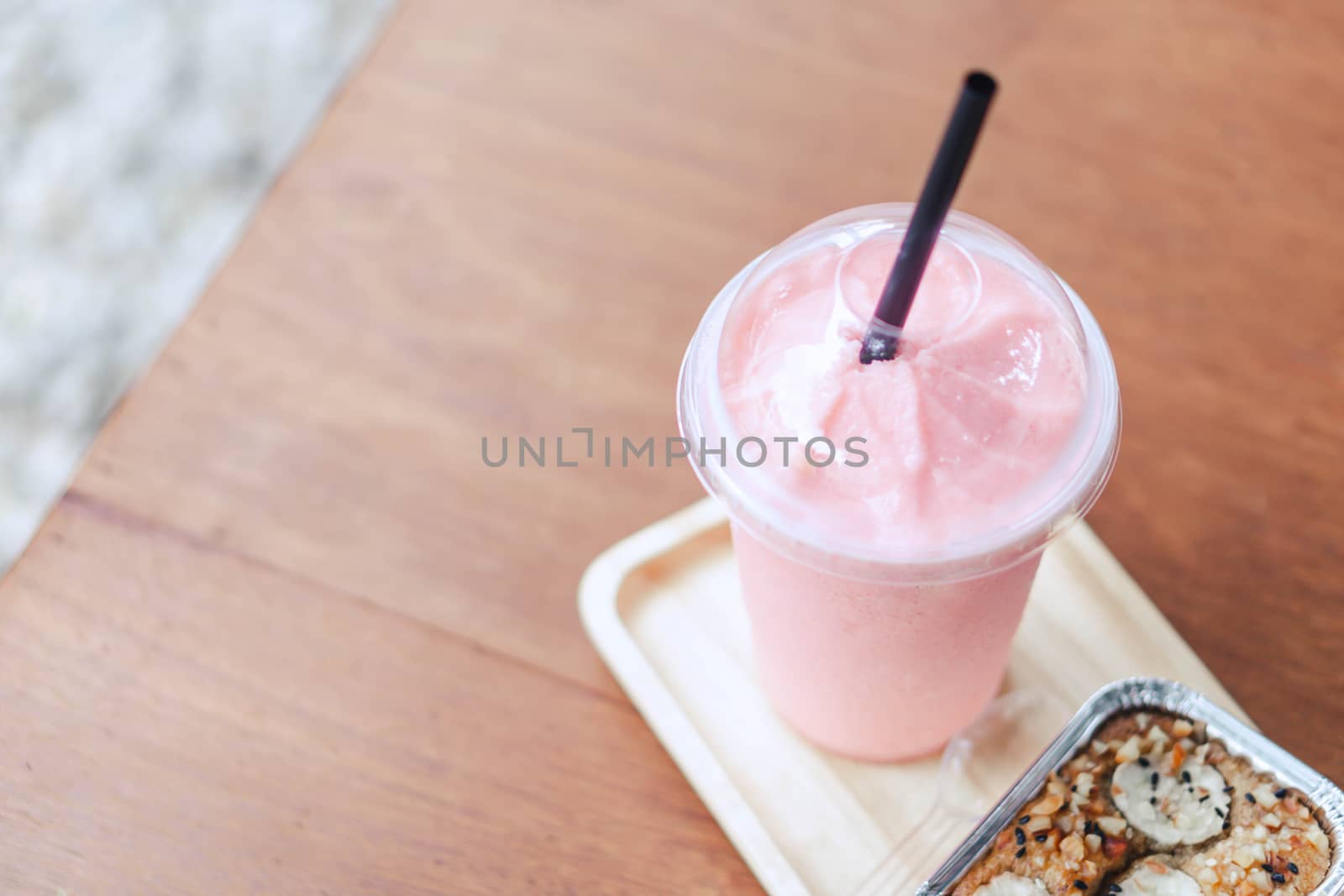 Closeup  strawberry smoothie and cake with green nature background, selective focus