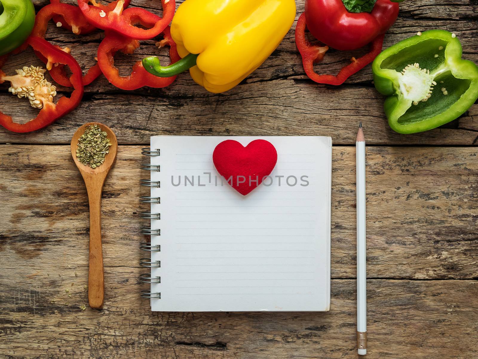 flat lay of blank recipe cooking book and utensils with herbs and colorful bell pepper over wooden background. top view with copy space. food recipe and cooking concept