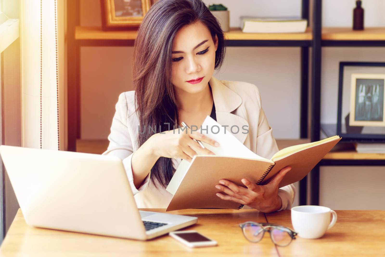 young Asian business woman working at workplace. beautiful Asian woman in casual suit working with reading book, prepare for meeting or interview in modern office. freelance, start up business in Asia by asiandelight