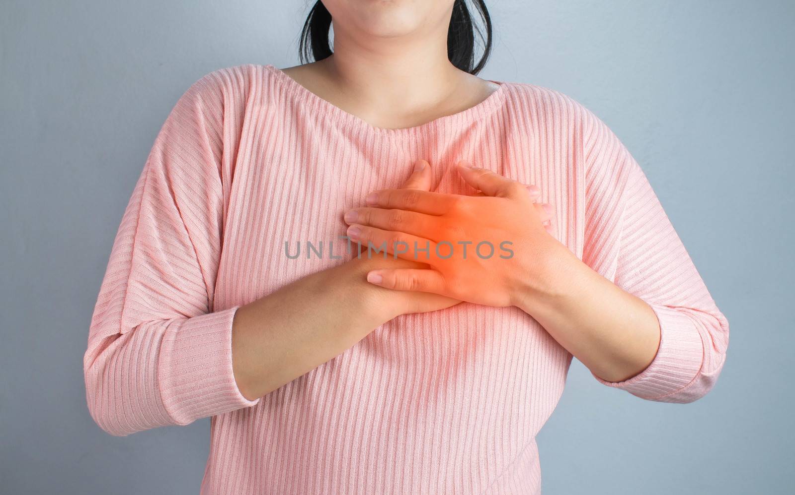 Asian young woman suffering from chest pain caused by heart disease.