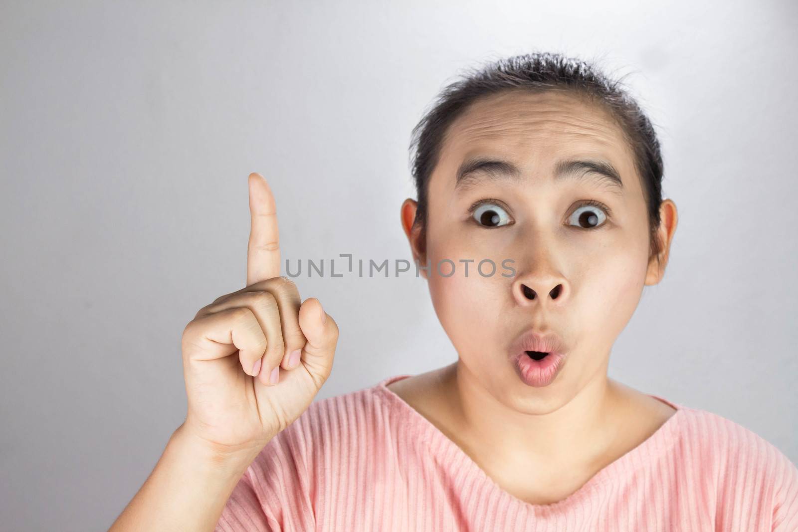 Portrait wow and surprised face of Asian young woman with hand point on empty space. by TEERASAK