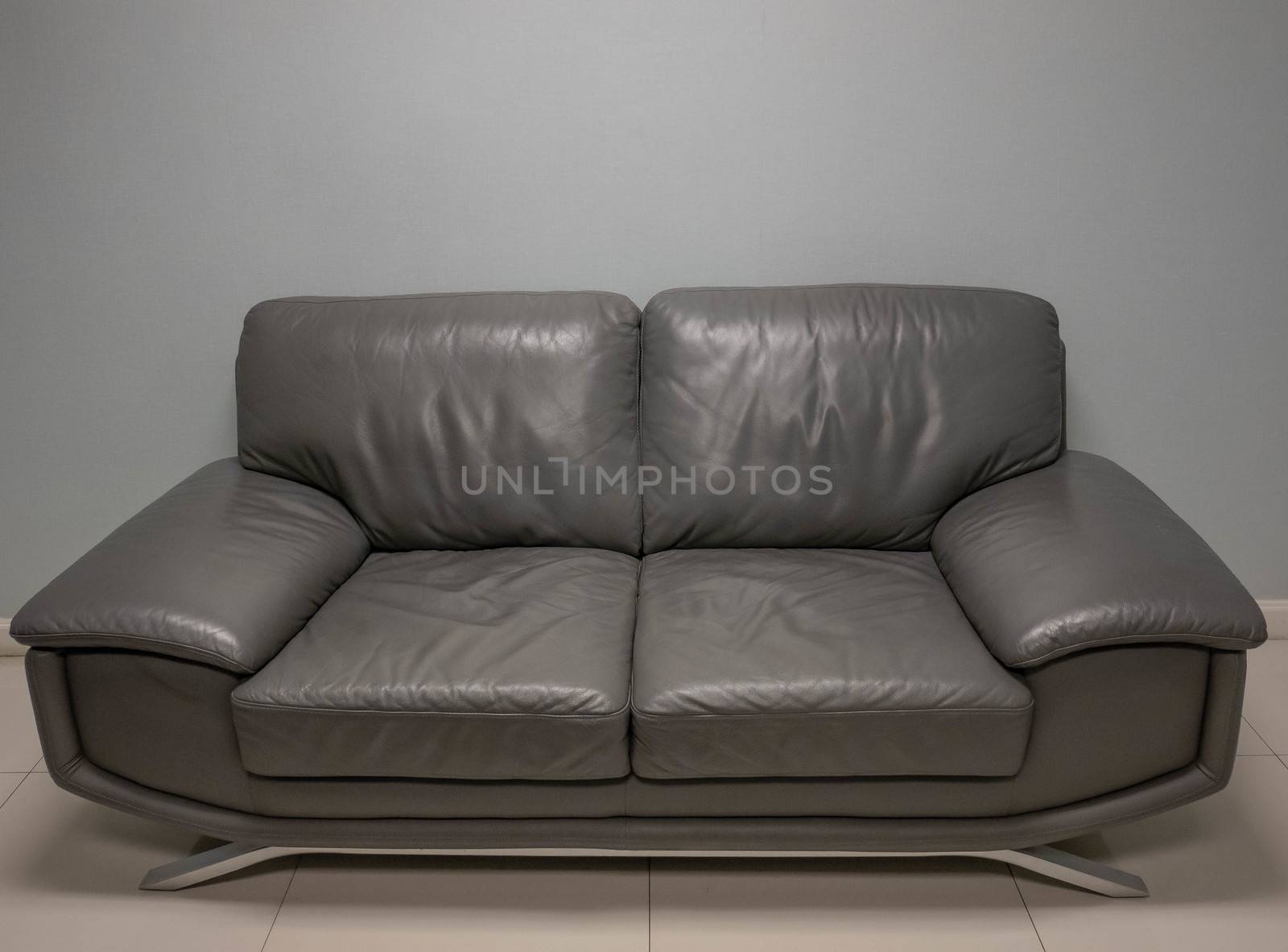 Front view of grey sofa on background. by TEERASAK