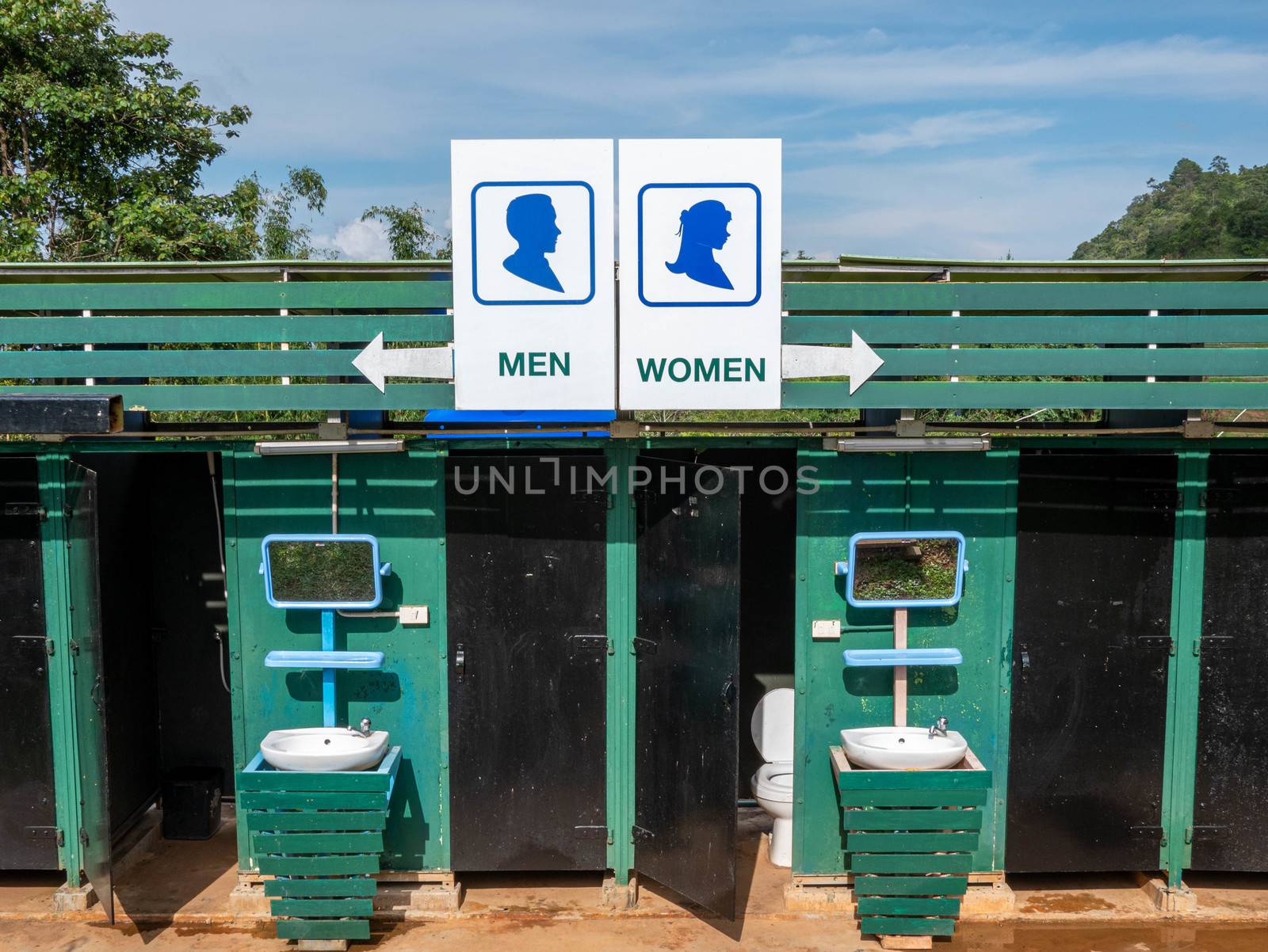 A sign outside public toilet in thailand with writing in English; Men and Women.