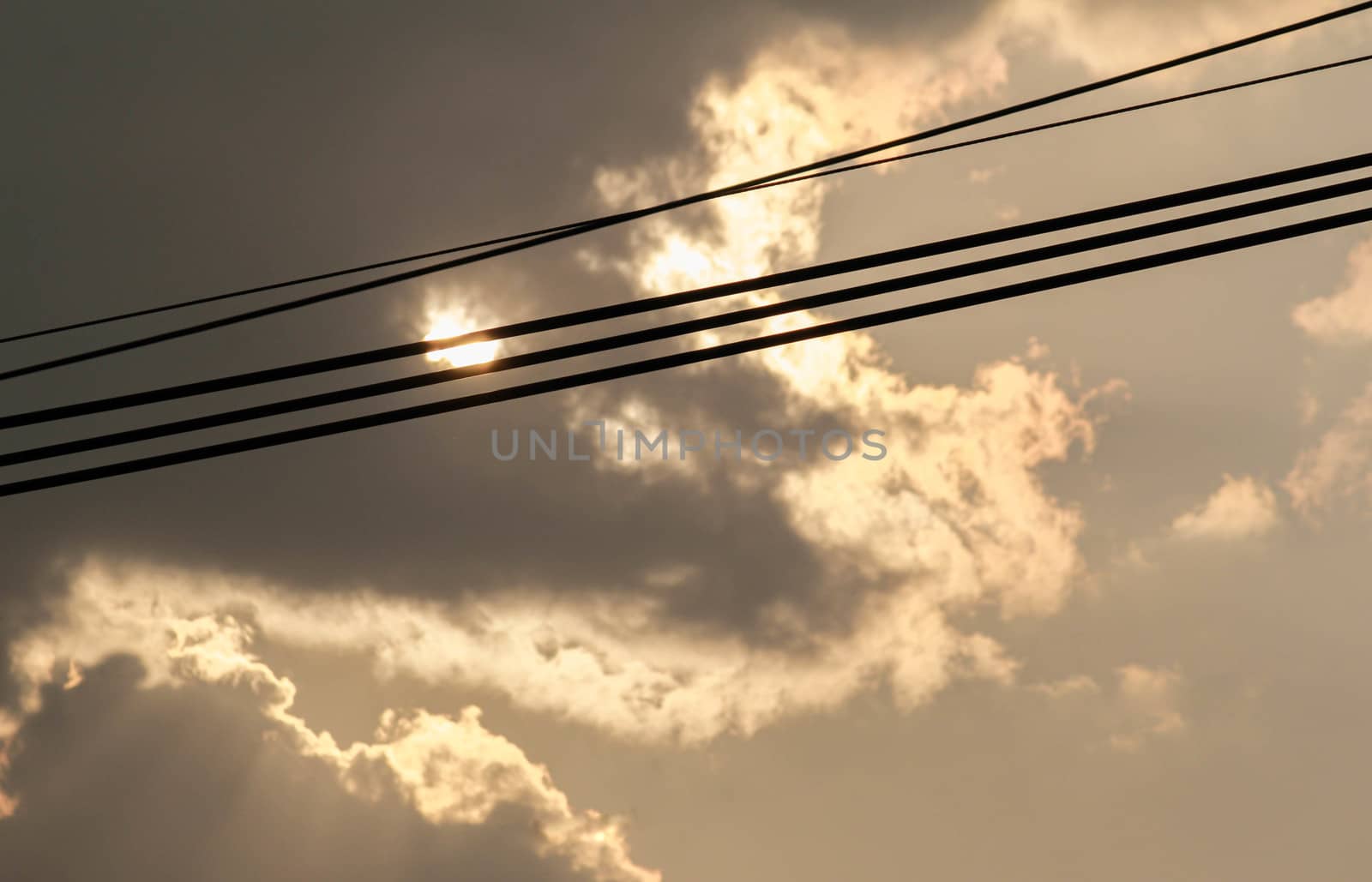 Cables of electric on dark gray dramatic sky with large clouds in rainy seasons.