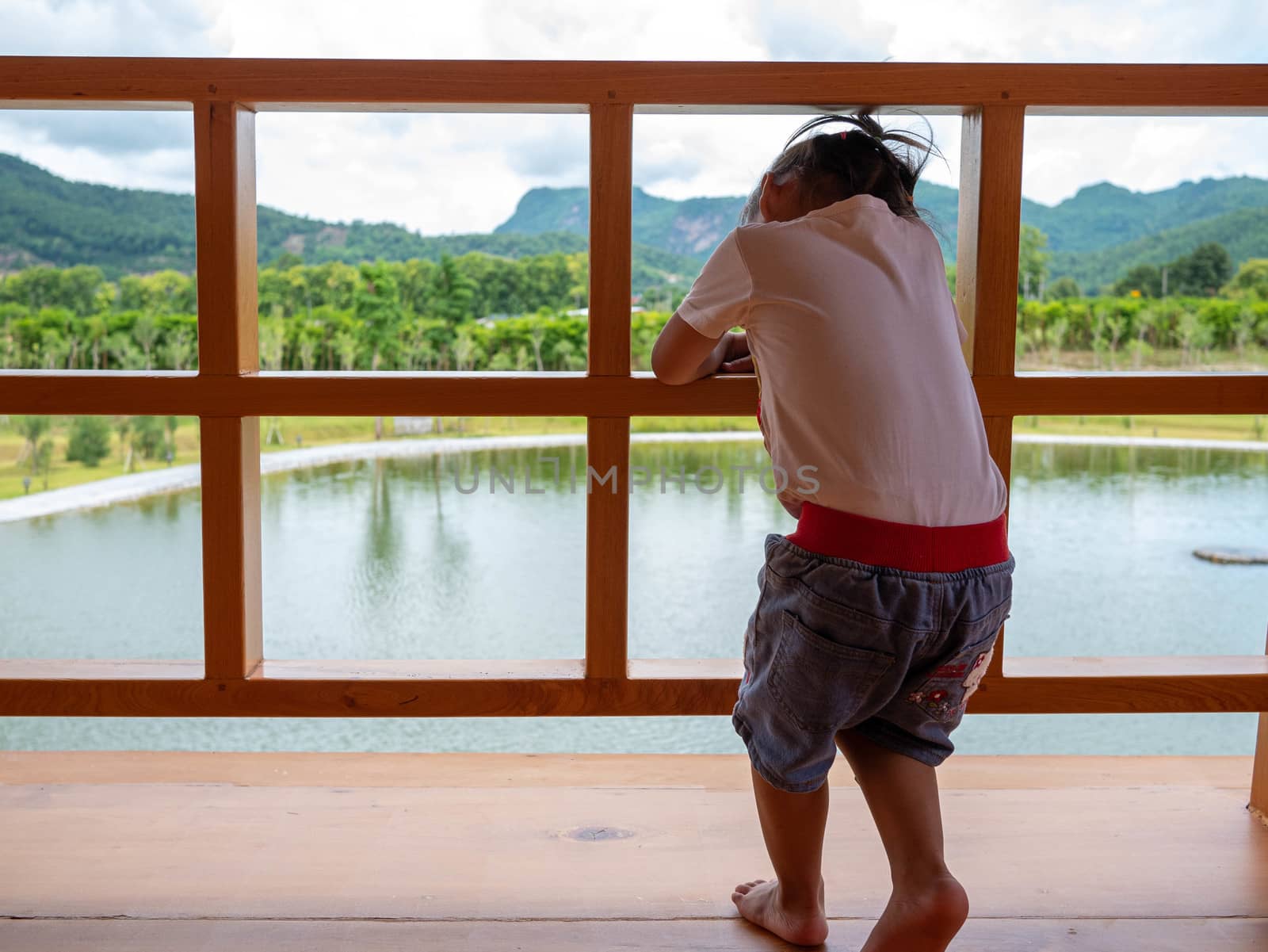 Asian young child girl look view lake in Hinoki Land; Japanese building style for tourist in Chaiprakarn district Chiang Mai,Thailand.