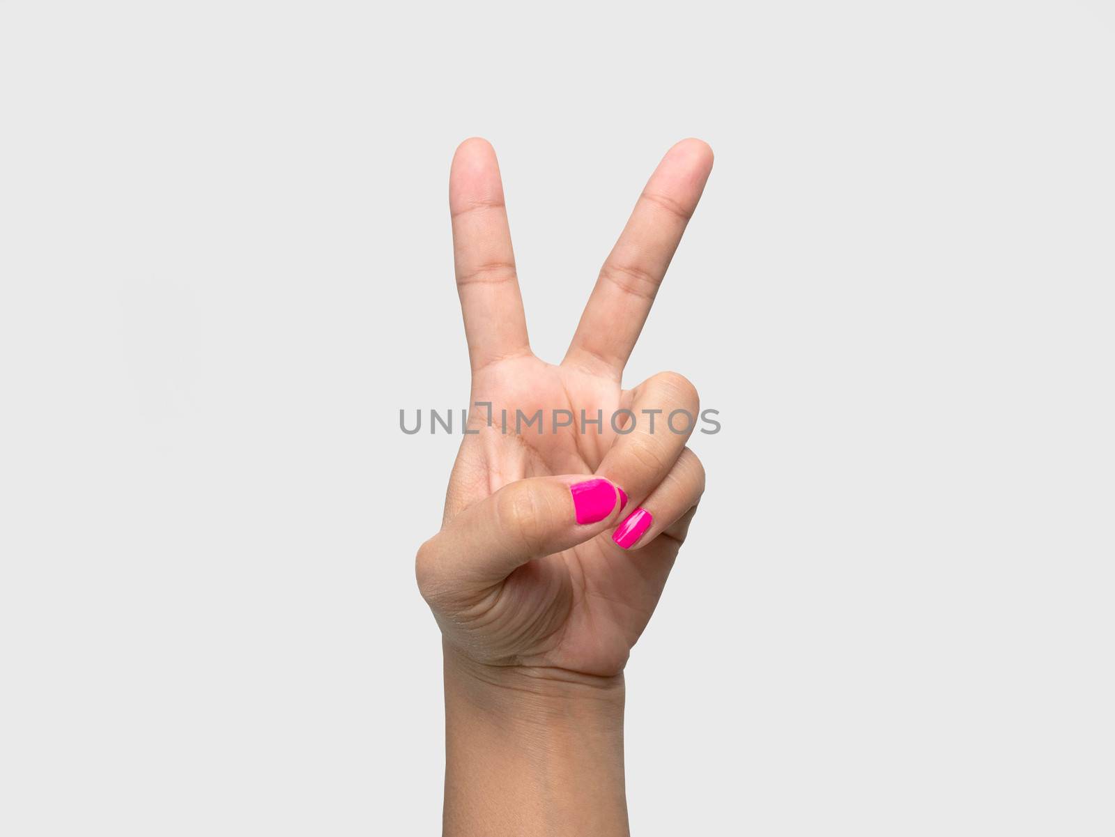 Close-up of a woman's hand showing V sign with a pink nail polish isolated on a white background. by TEERASAK