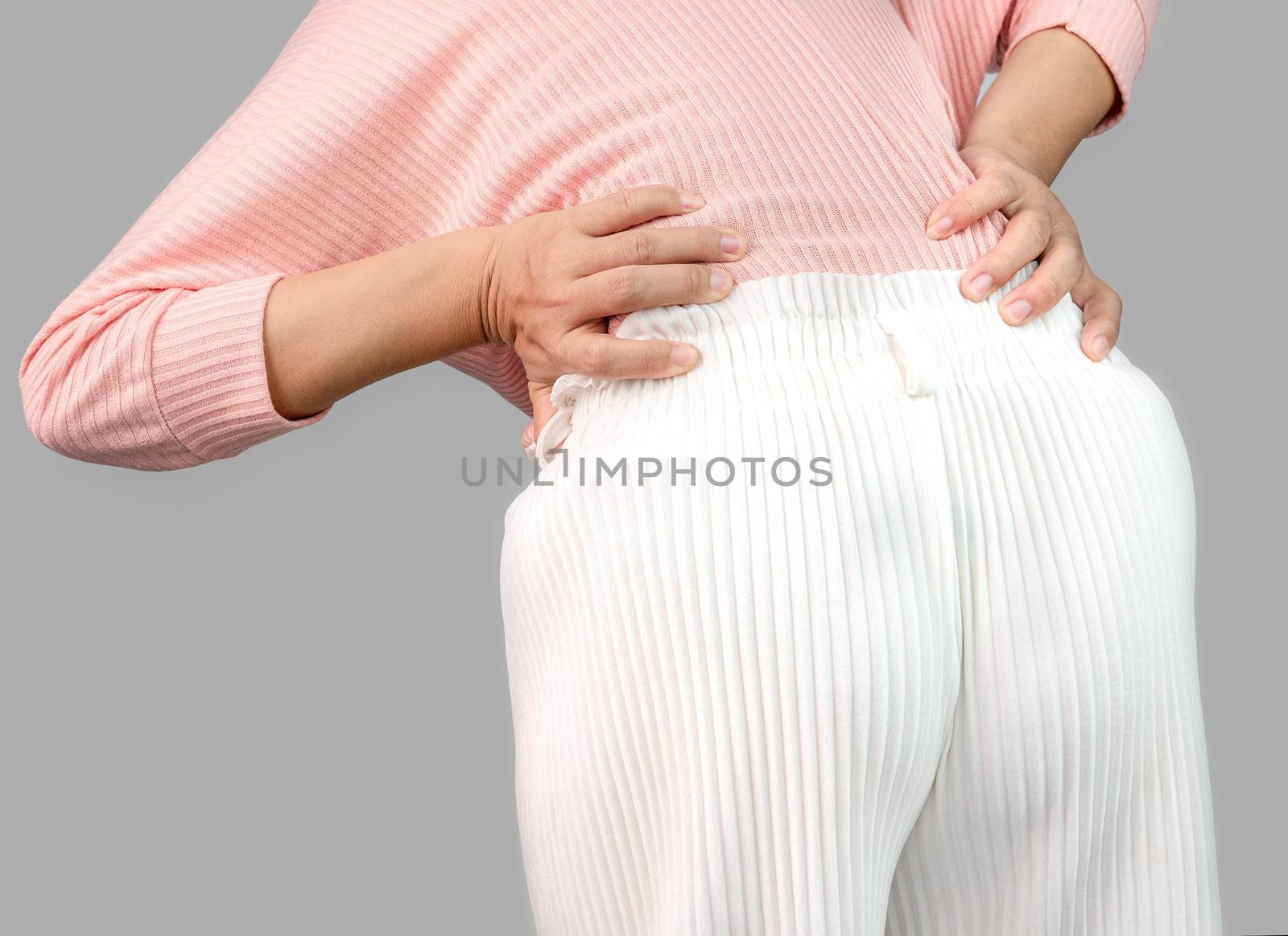 Woman suffering from back pain after work hard at home. Health care concept. by TEERASAK