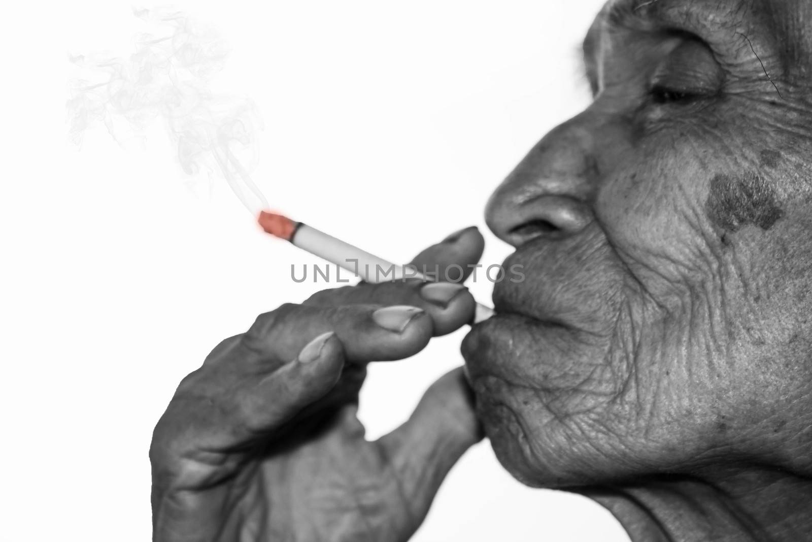 World No Tobacco Day; Asian senior man is smoking isolated on wh by TEERASAK