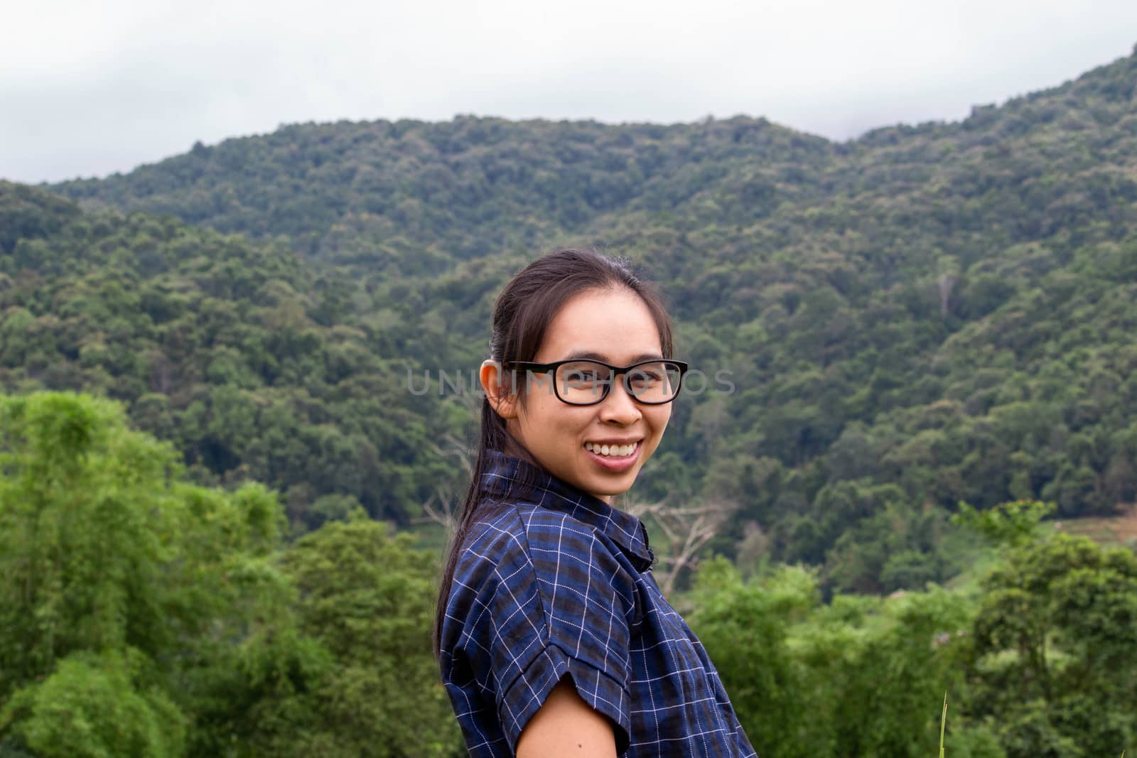 Portrait of young happy woman stand and smile on mountain background.