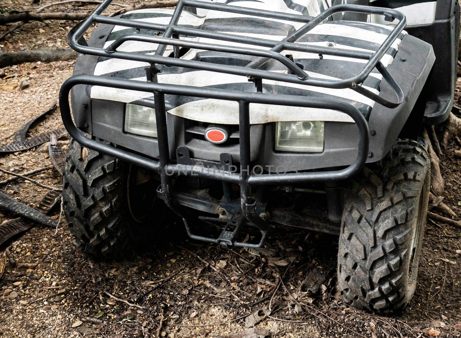 Front of ATV offroad parked alone at the forest. by TEERASAK