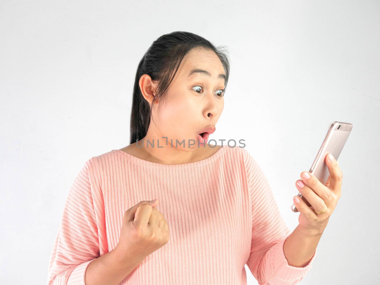 Asian woman shocked what she see in the smartphone and made a gesture of success, Isolated on white background.