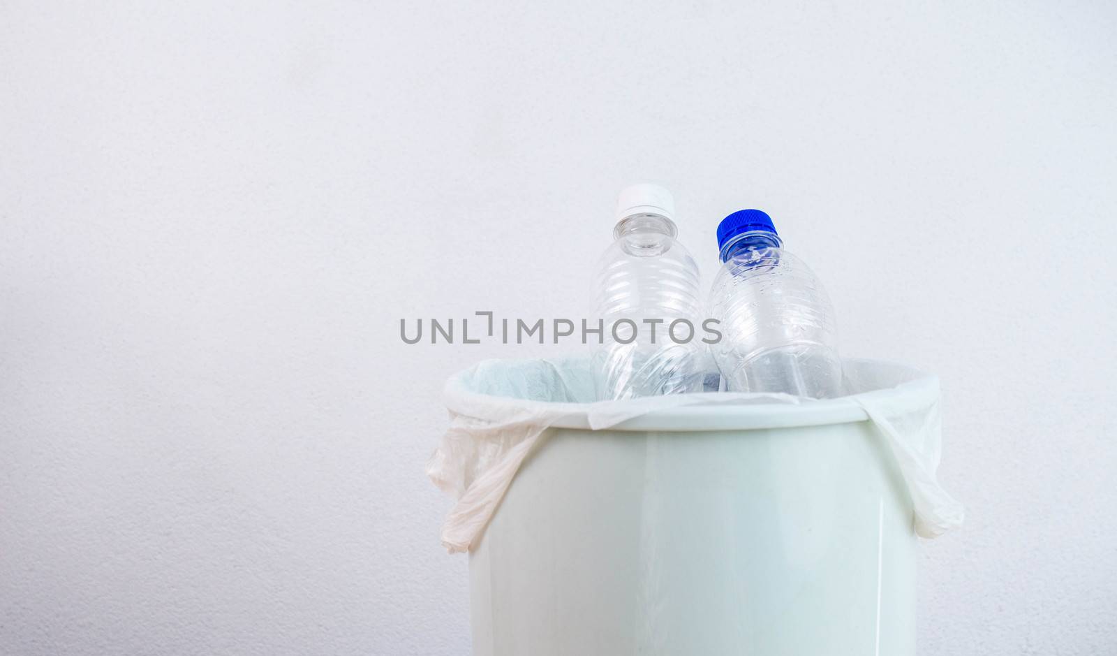 Empty plastic water bottle in recycling bin waiting to be taken to recycle. Concept save the earth. by TEERASAK