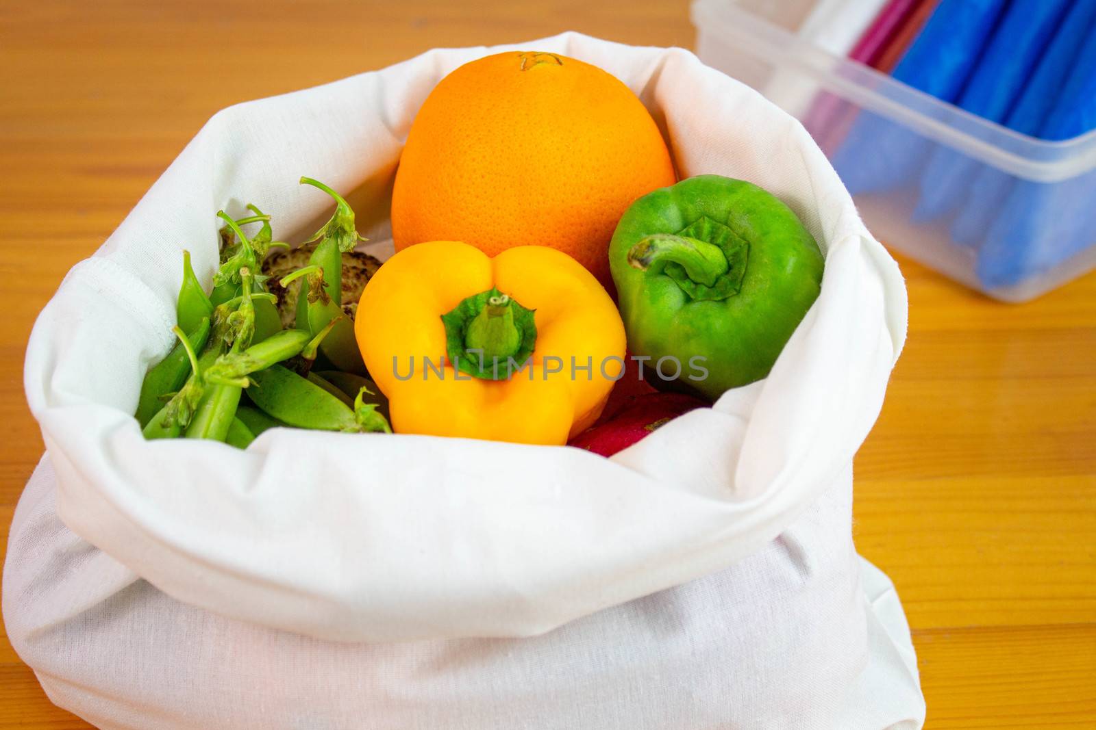 Fresh fruits and vegetables organic in eco cotton fabric bags on wooden table, not used plastic bag. Concept save the earth.