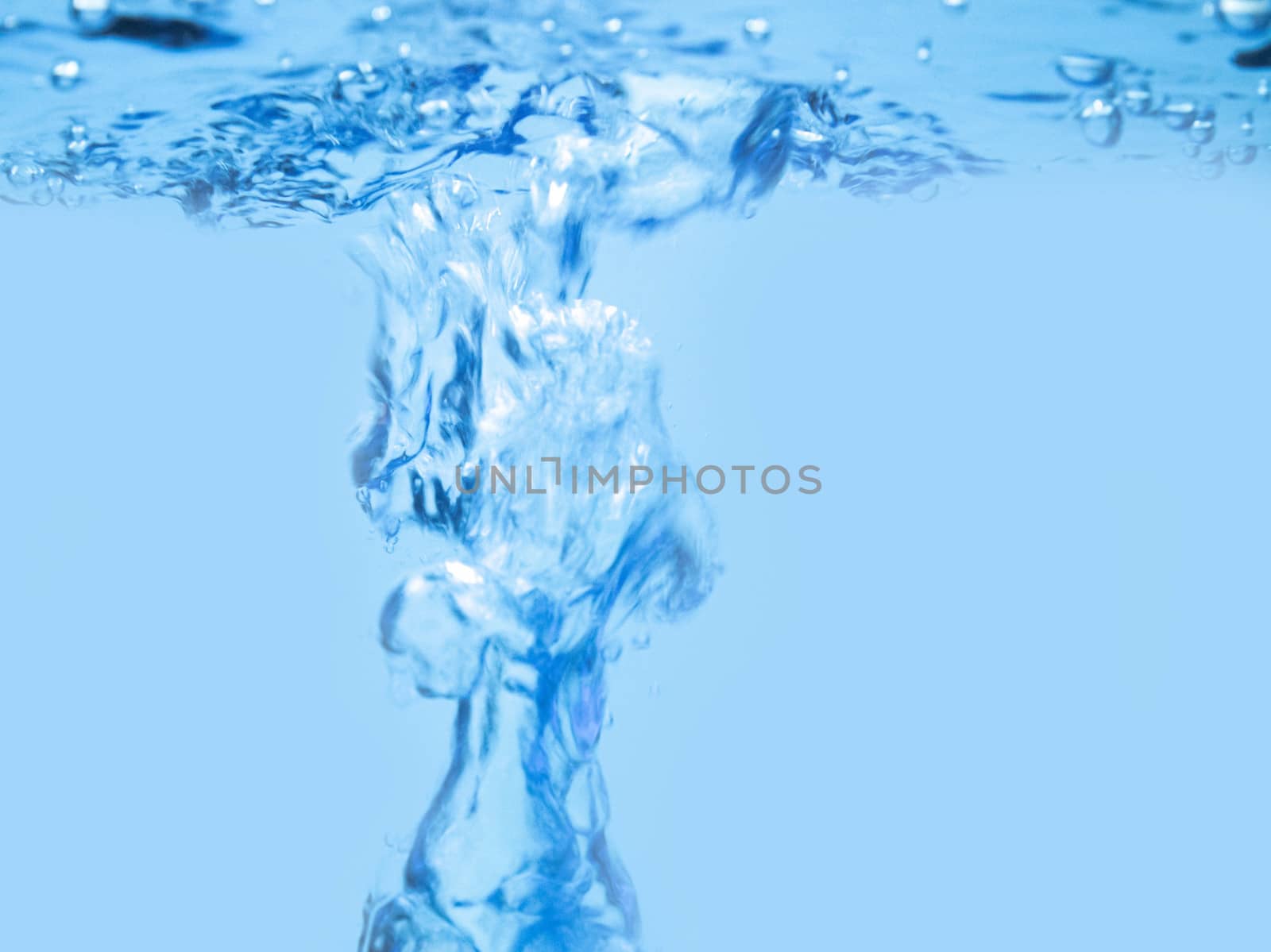 Air bubbles rising up to surface in blue pure water. Abstract background.