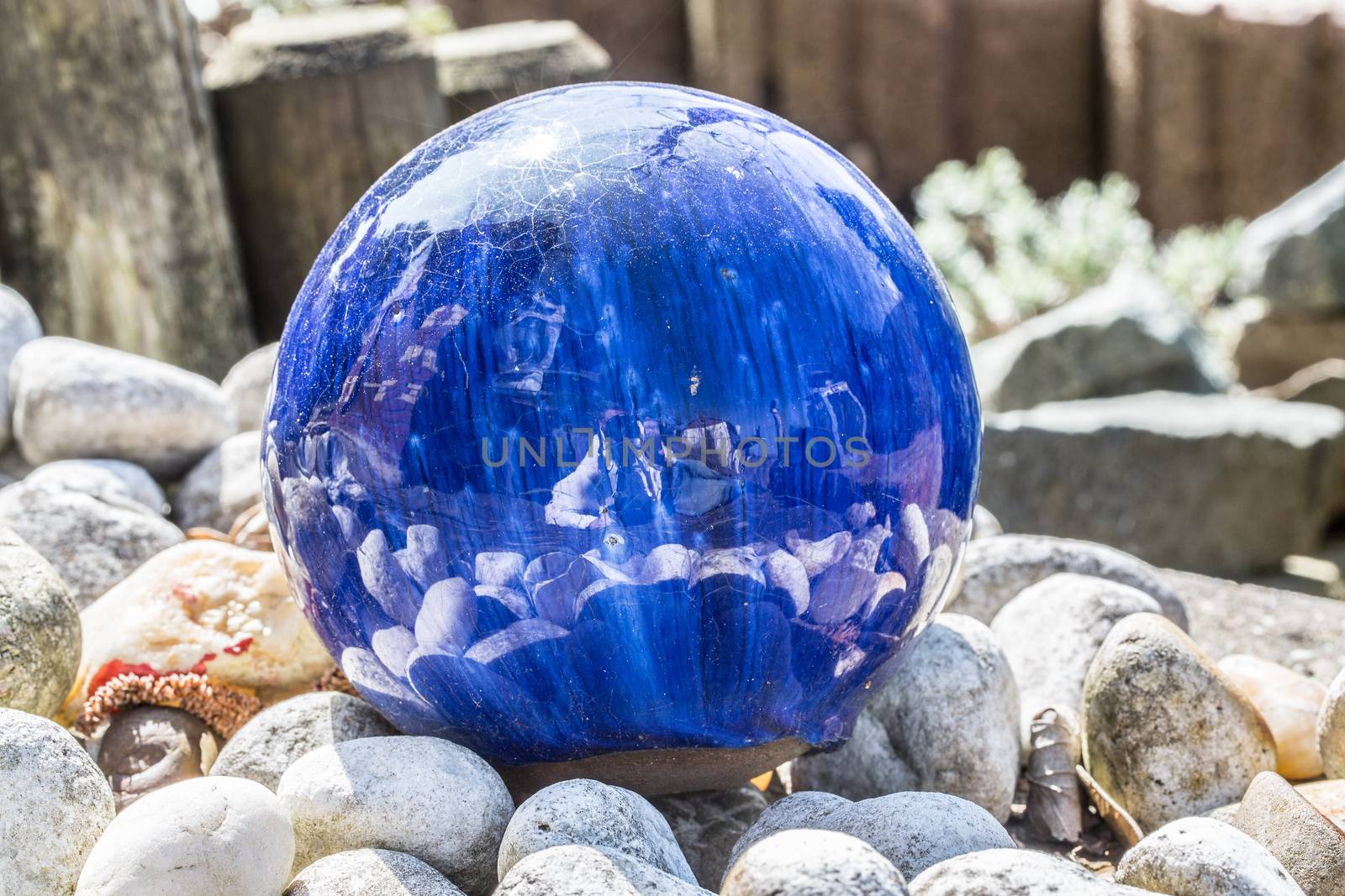 blue glass ball in the gravel bed