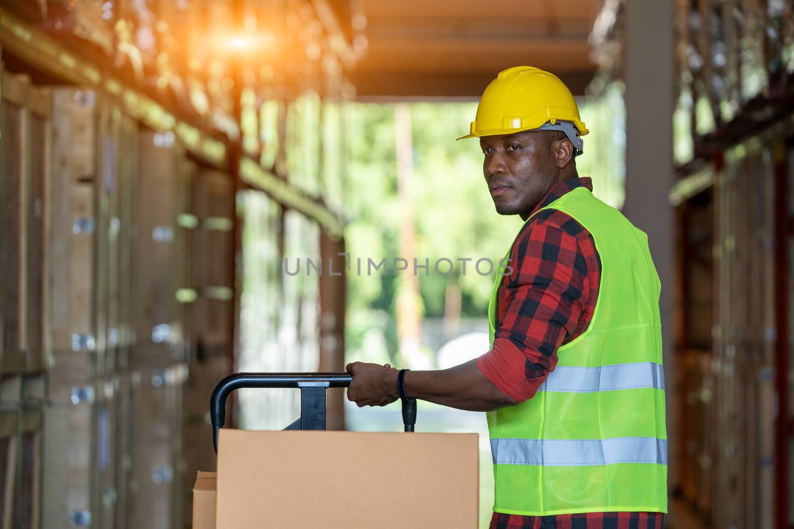 Warehouse worker loading or unloading boxes at warehouse by Visoot