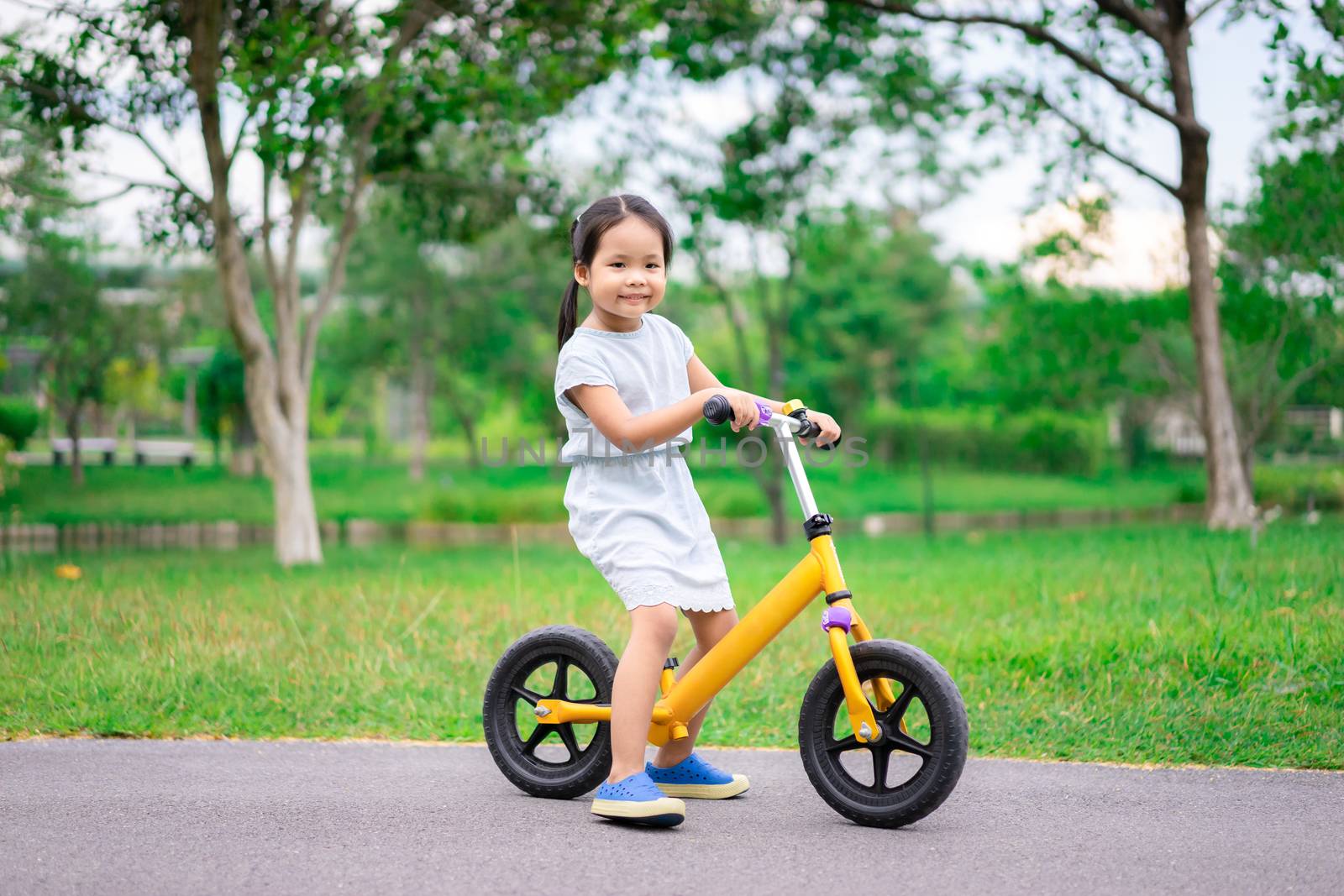 Little girl riding balance bike in the park