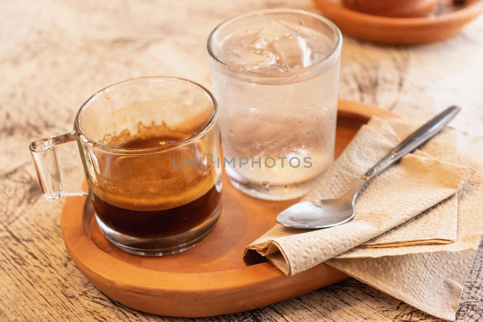 Espresso coffee in glass cup on wooden tray