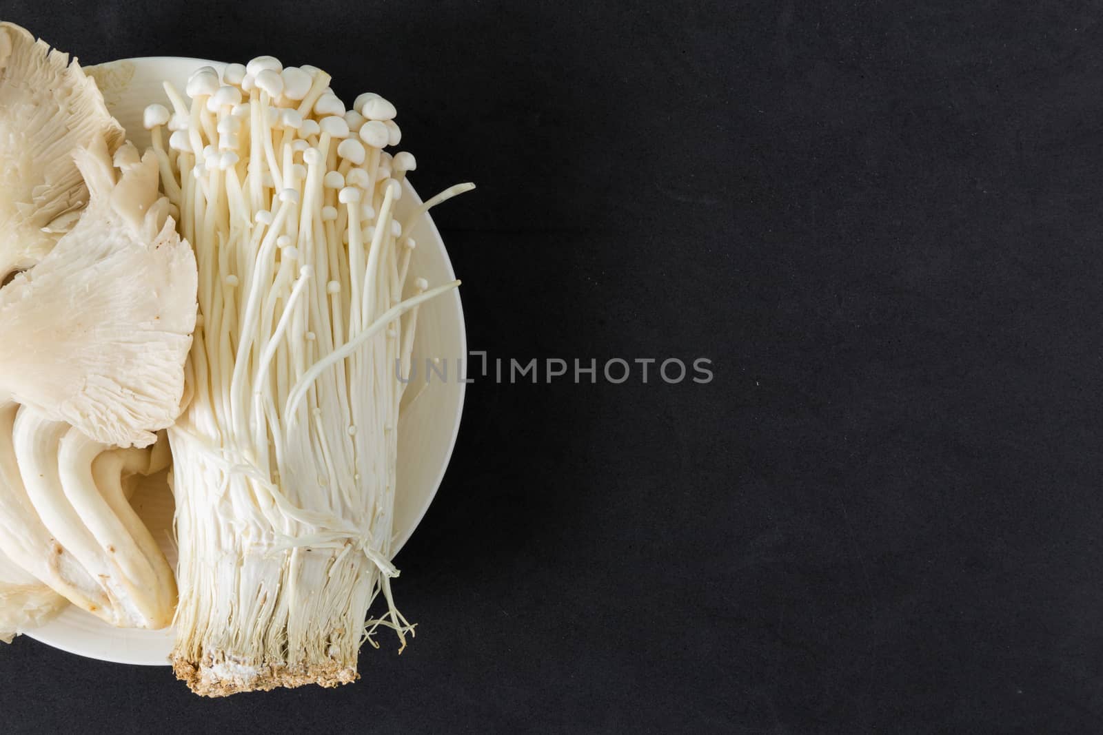 Various kinds of mushroom in a plate on black background.