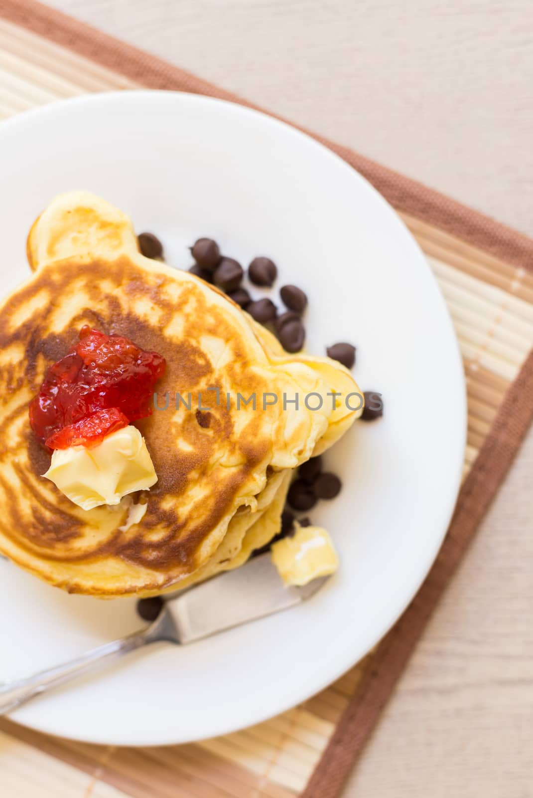 Fresh and hot pancakes to be eaten with butter, strawberry, and chocolate.