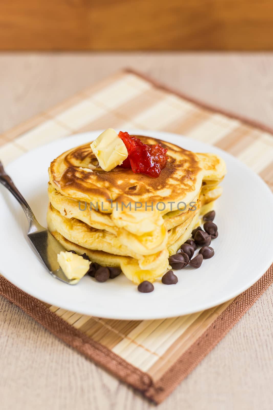 Fresh and hot pancakes to be eaten with butter, strawberry, and chocolate.