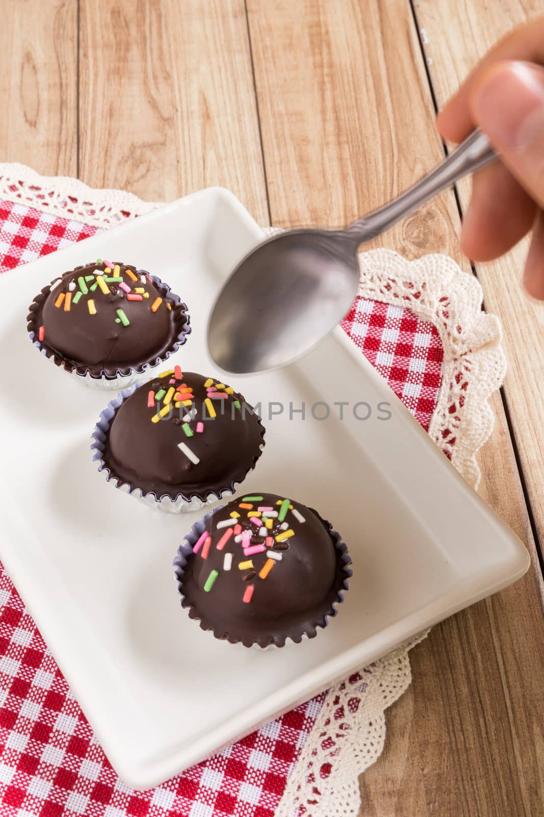 Fresh chocolate ball cakes sprinkled with colorful sugar balls.