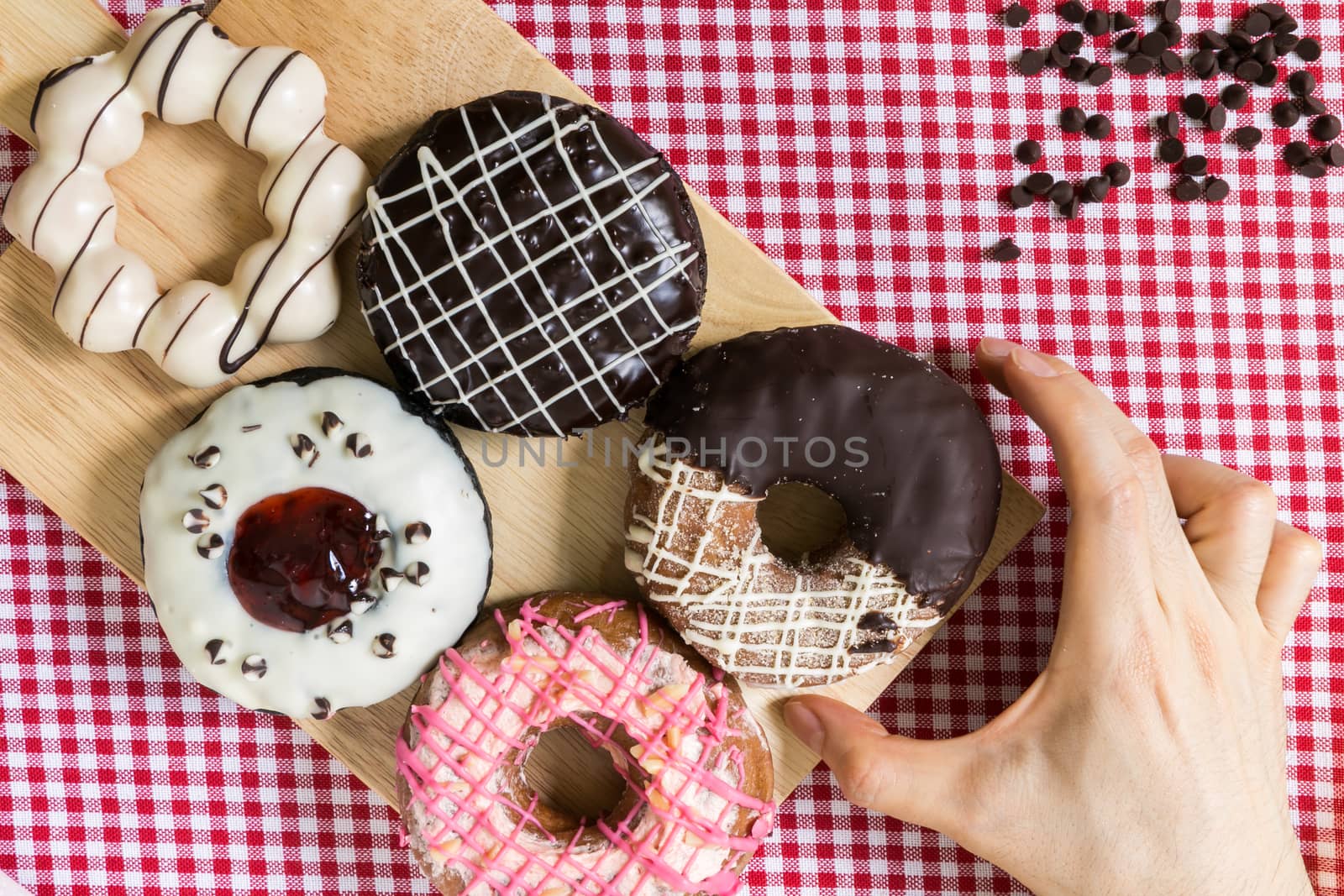 Hand Taking Colorful Doughnut or Donut for Relax Coffee Break Time.