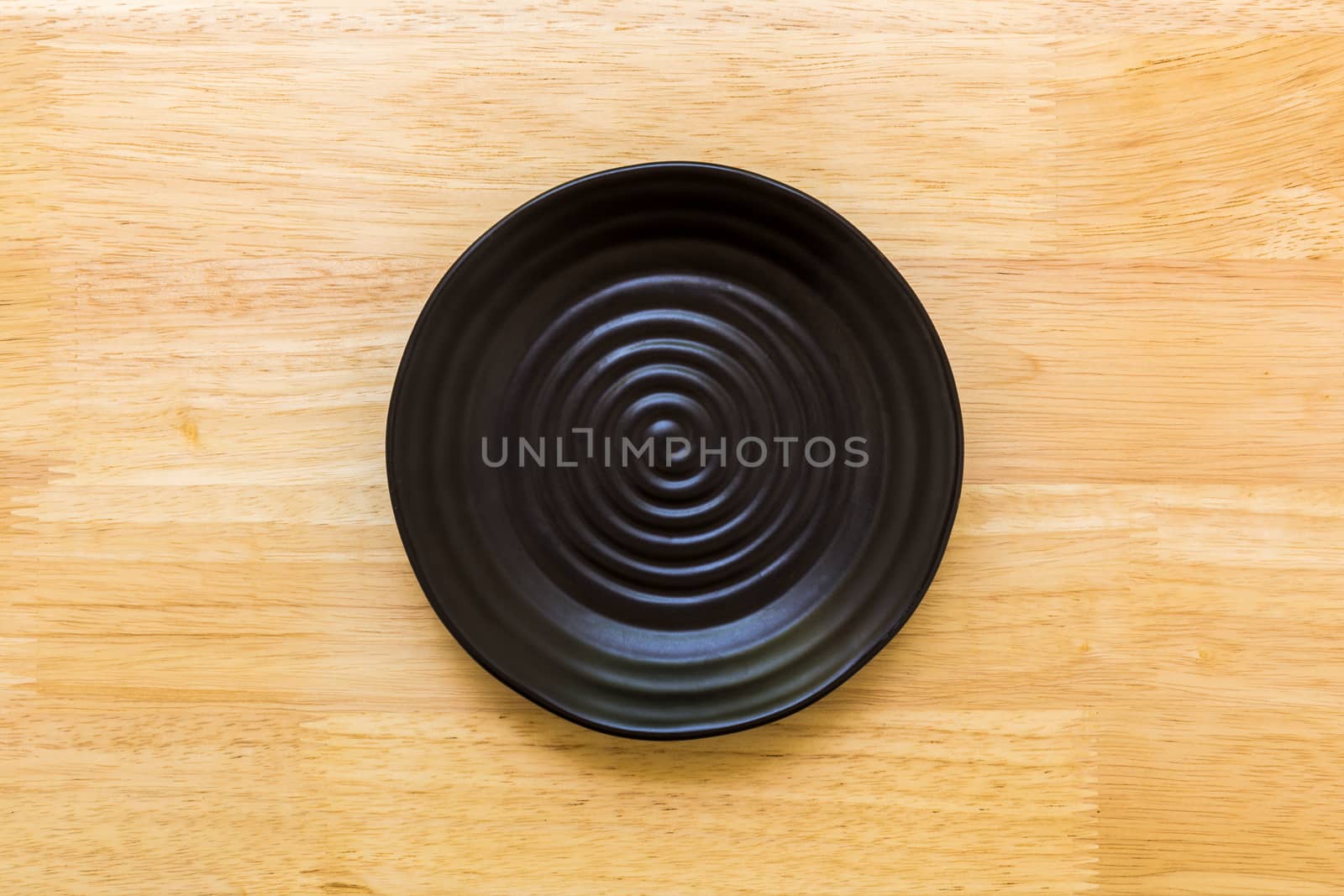 Empty plate without spoon and fork on table background.