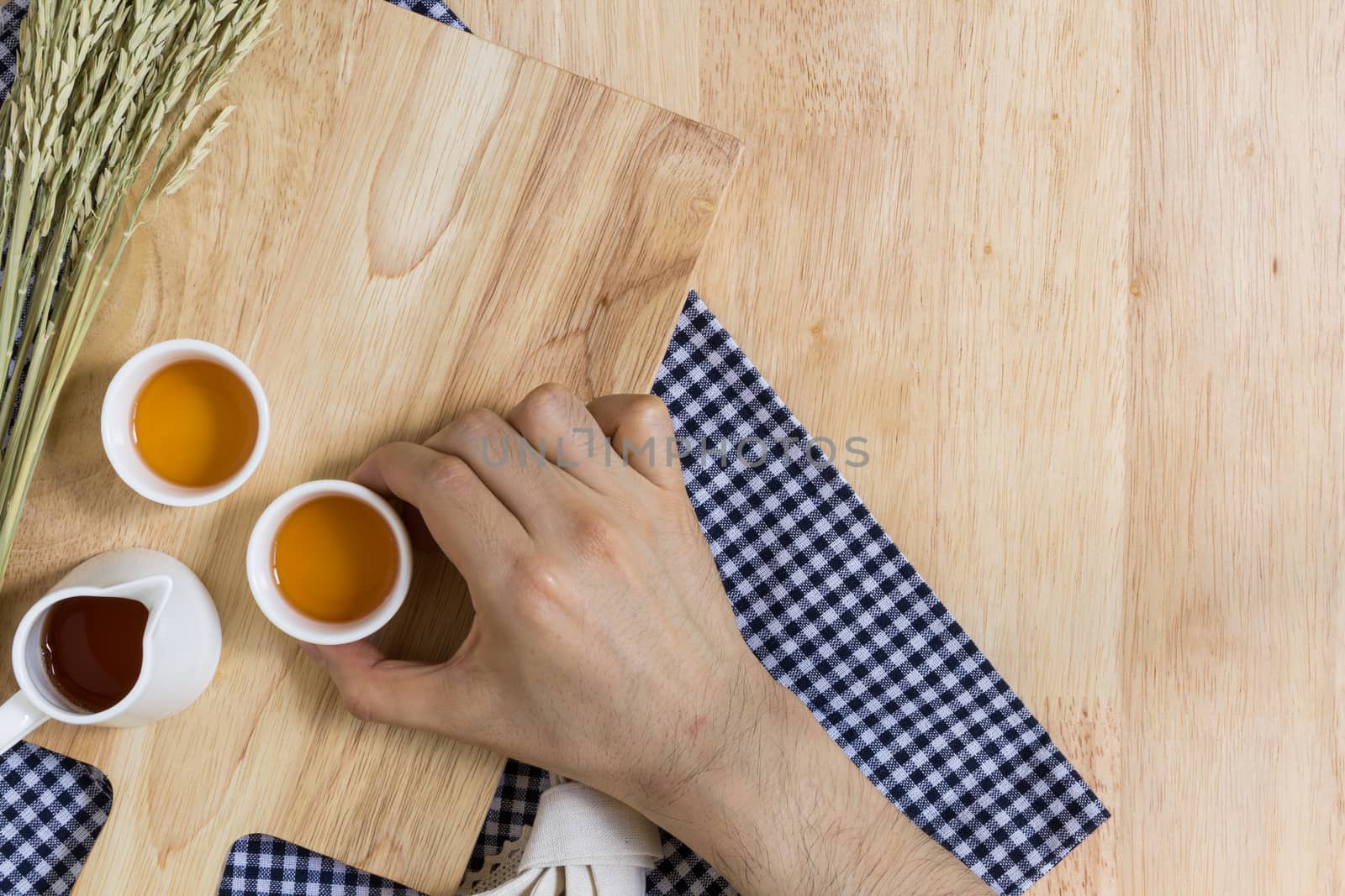 Hand Taking Tea Cup on Wood Texture Background