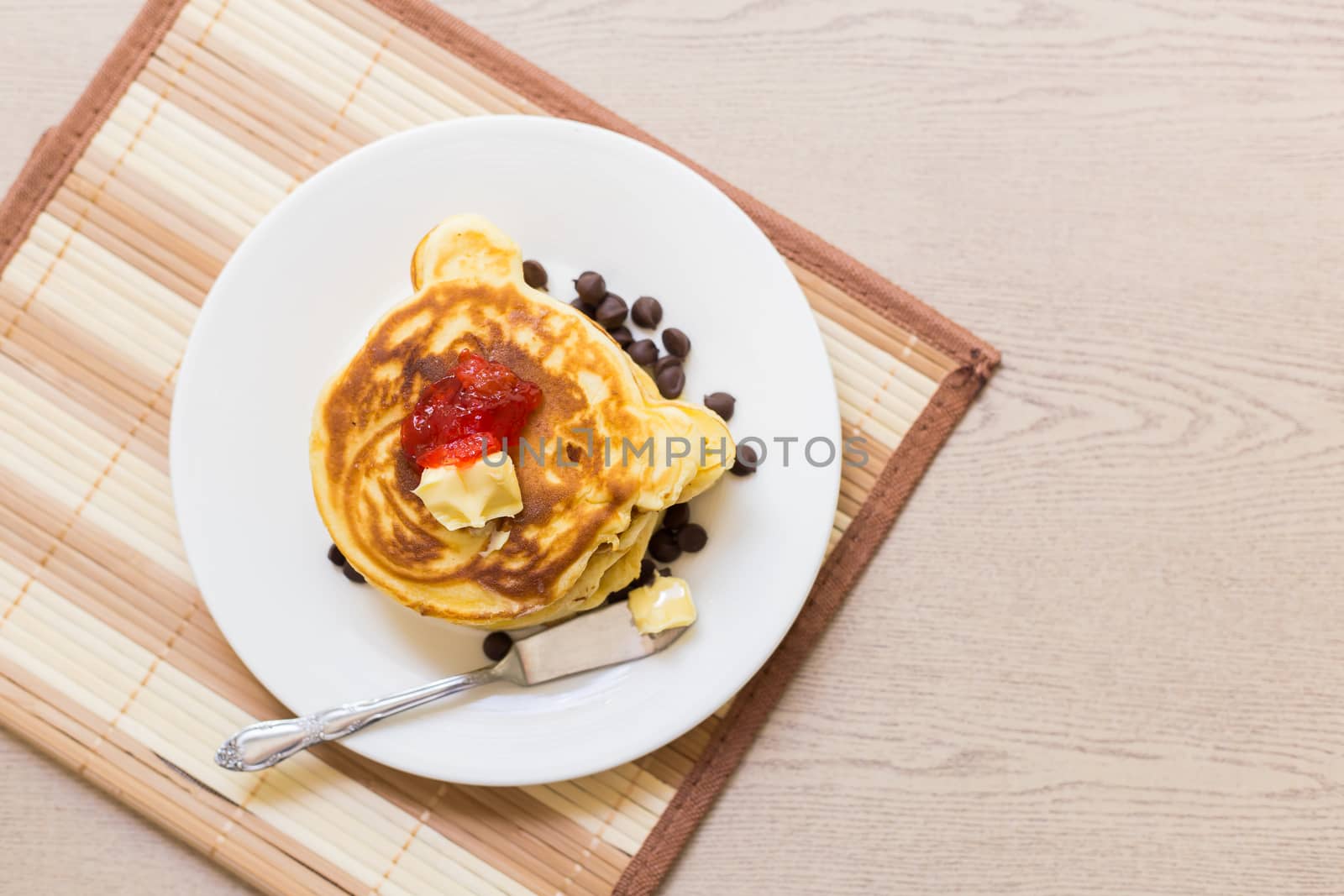 Fresh and hot pancakes to be eaten with butter, strawberry, and chocolate.