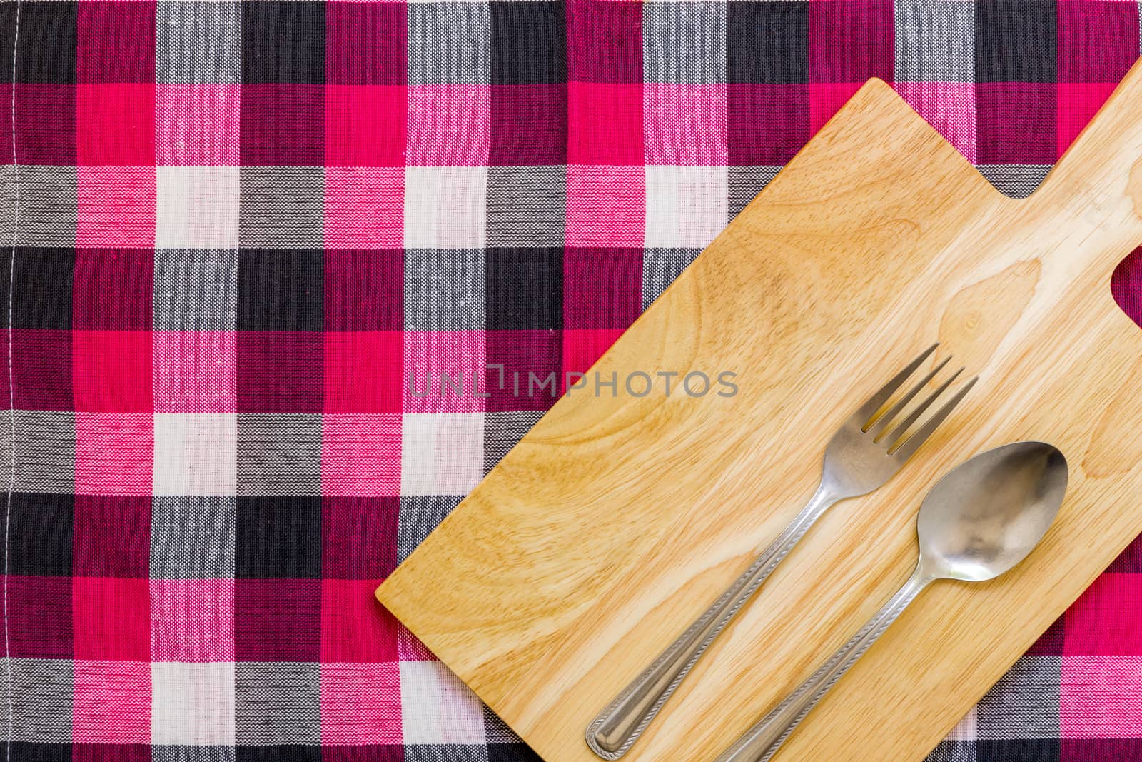 Empty plate with spoon and fork on table background.