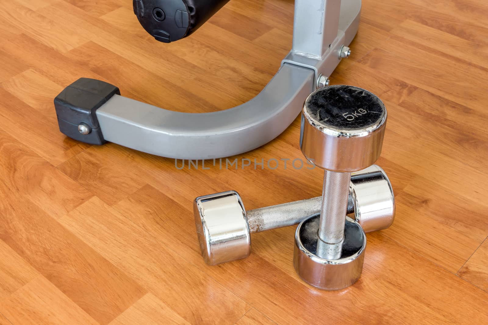 Dumbbells putting next to each other on wooden floor at the gym