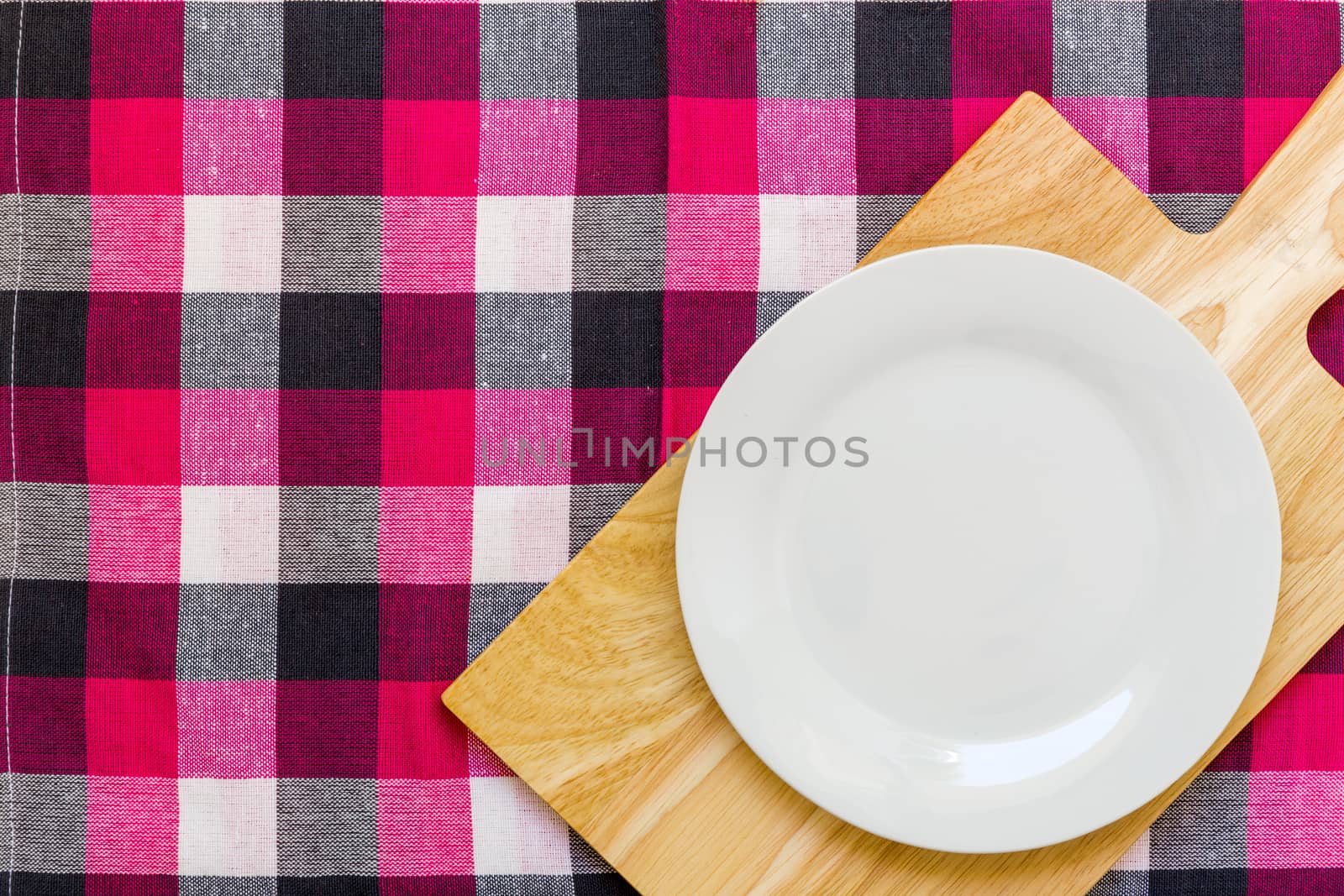 Empty plate without spoon and fork on table background.