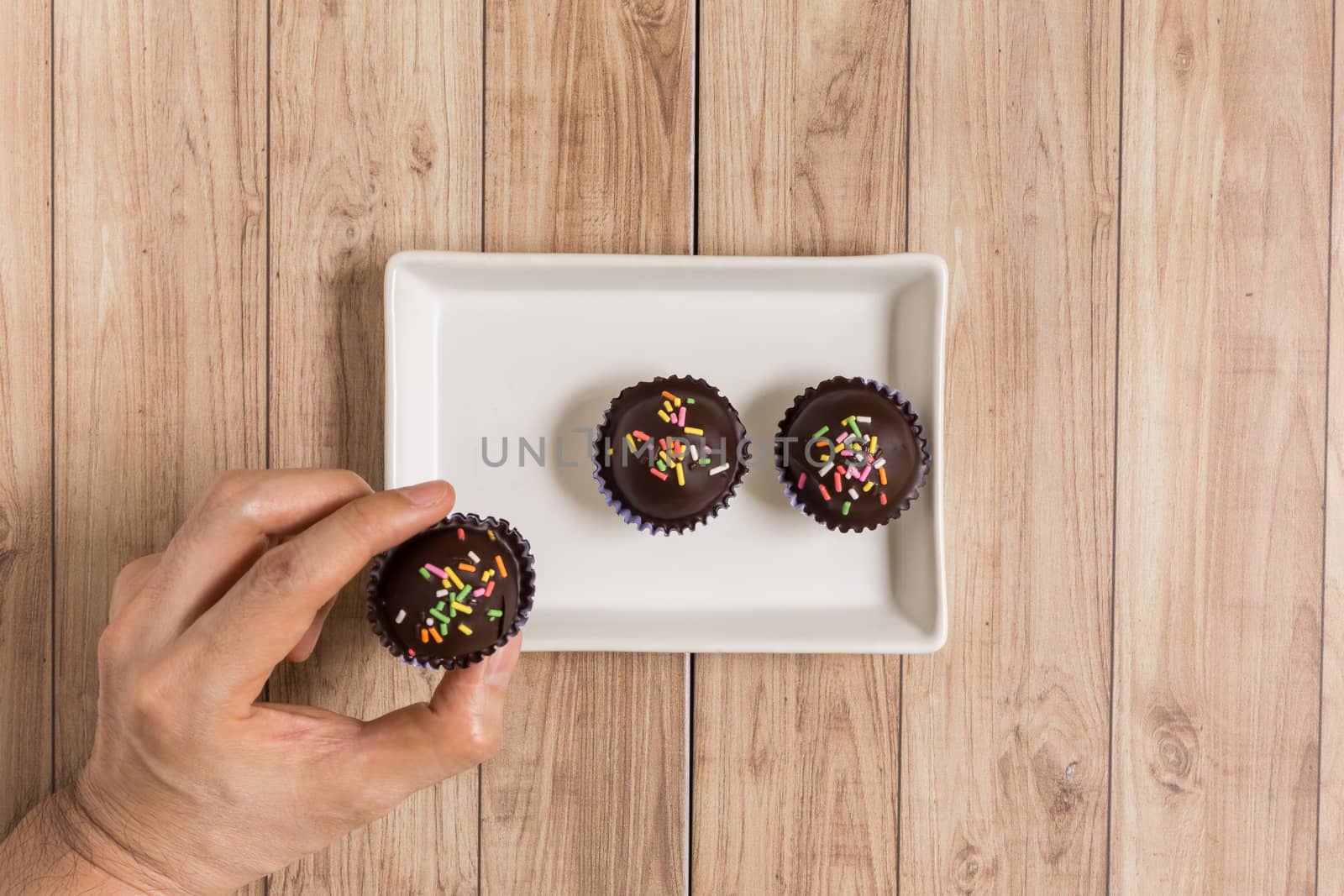 Fresh chocolate ball cakes sprinkled with colorful sugar balls.